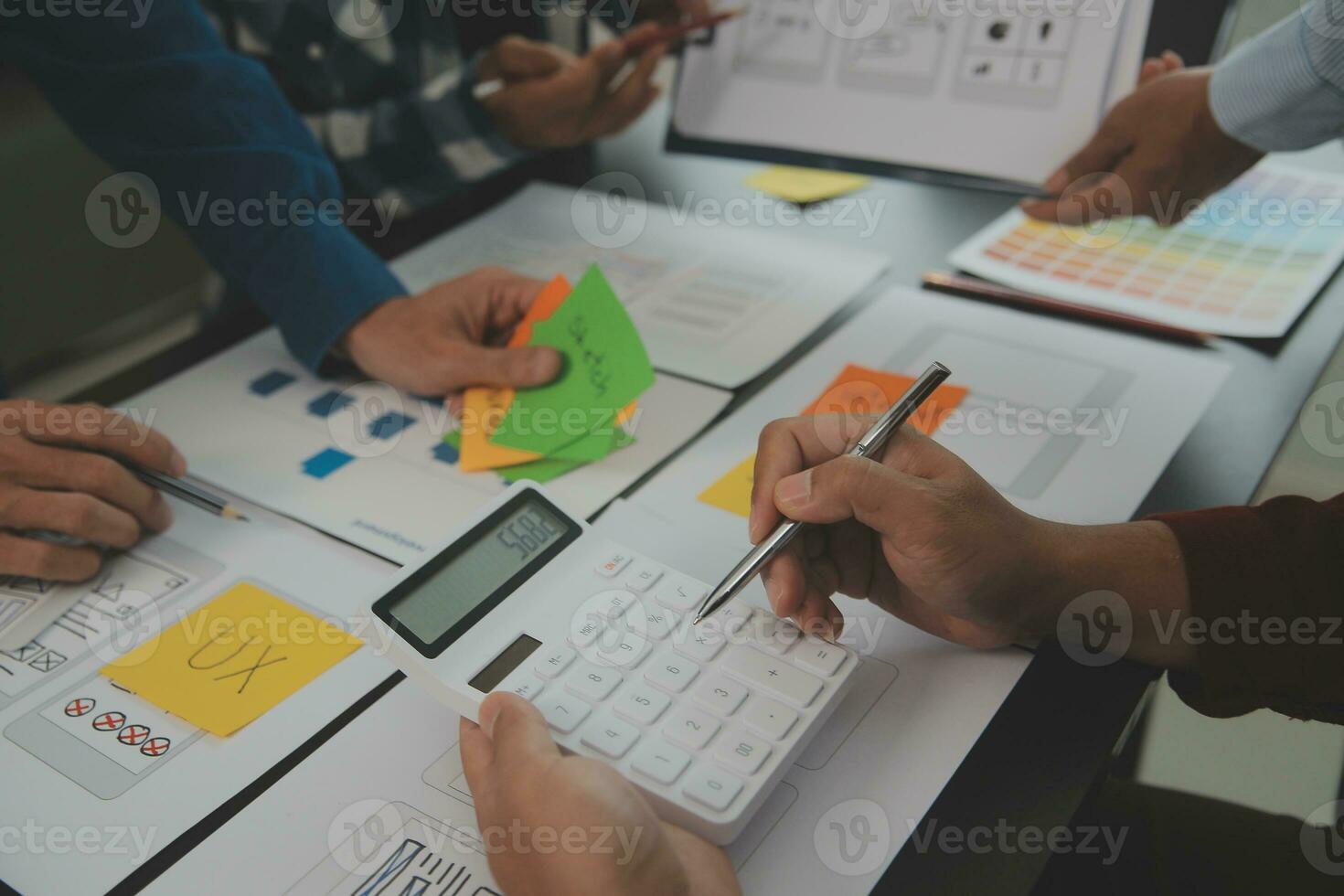 Close up ux developer and ui designer brainstorming about mobile app interface wireframe design on table with customer breif and color code at modern office.Creative digital development agency photo