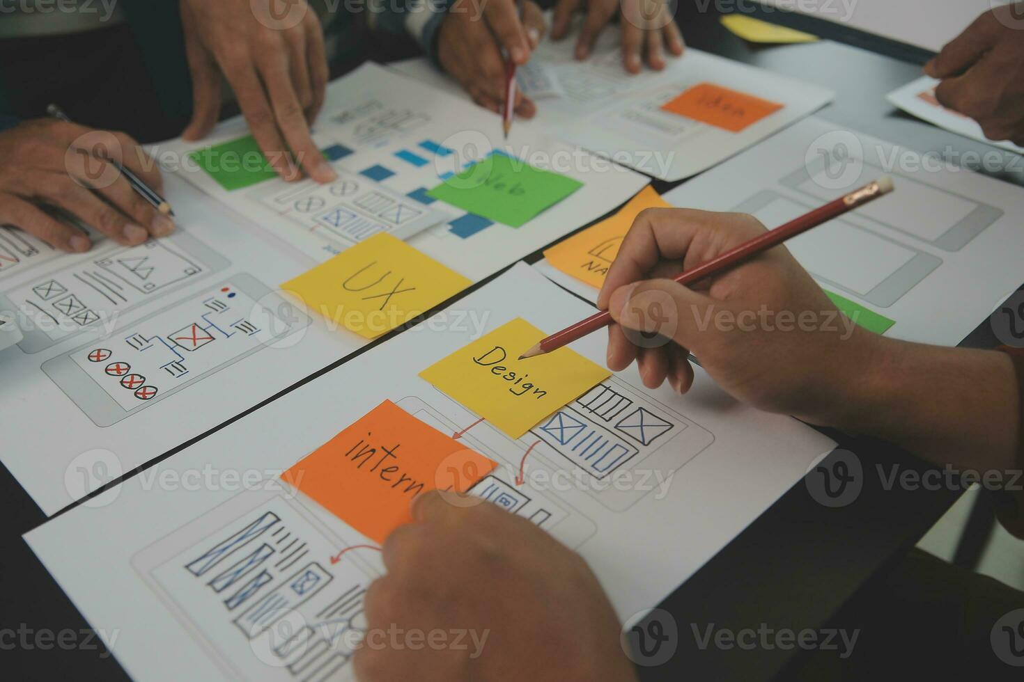 Close up ux developer and ui designer brainstorming about mobile app interface wireframe design on table with customer breif and color code at modern office.Creative digital development agency photo