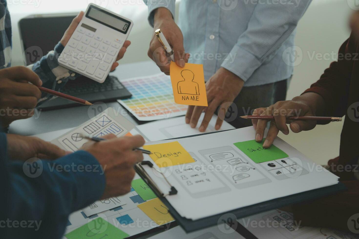 Close up ux developer and ui designer brainstorming about mobile app interface wireframe design on table with customer breif and color code at modern office.Creative digital development agency photo