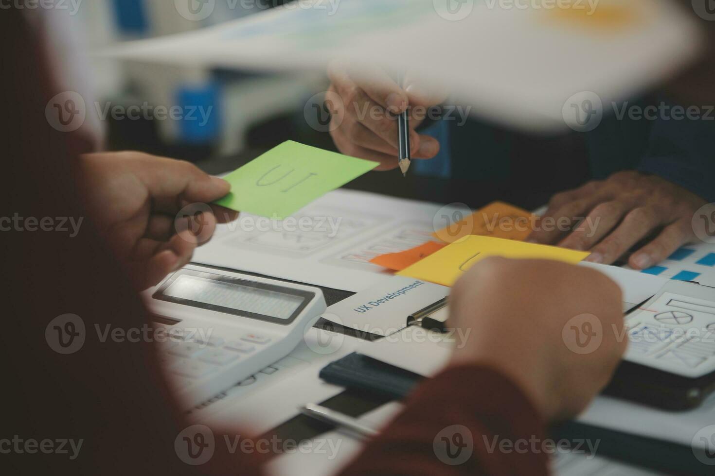 Close up ux developer and ui designer brainstorming about mobile app interface wireframe design on table with customer breif and color code at modern office.Creative digital development agency photo