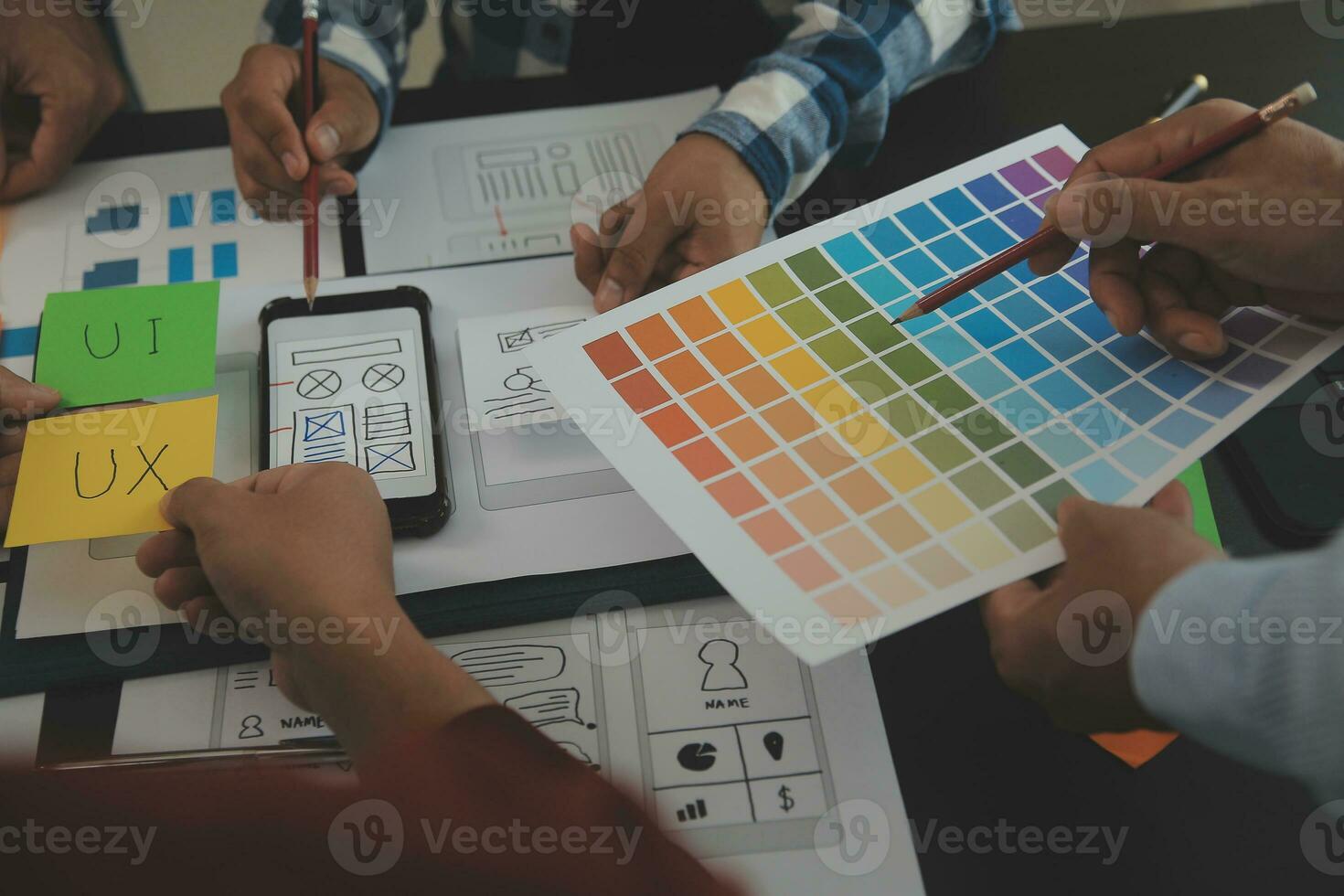 Close up ux developer and ui designer brainstorming about mobile app interface wireframe design on table with customer breif and color code at modern office.Creative digital development agency photo