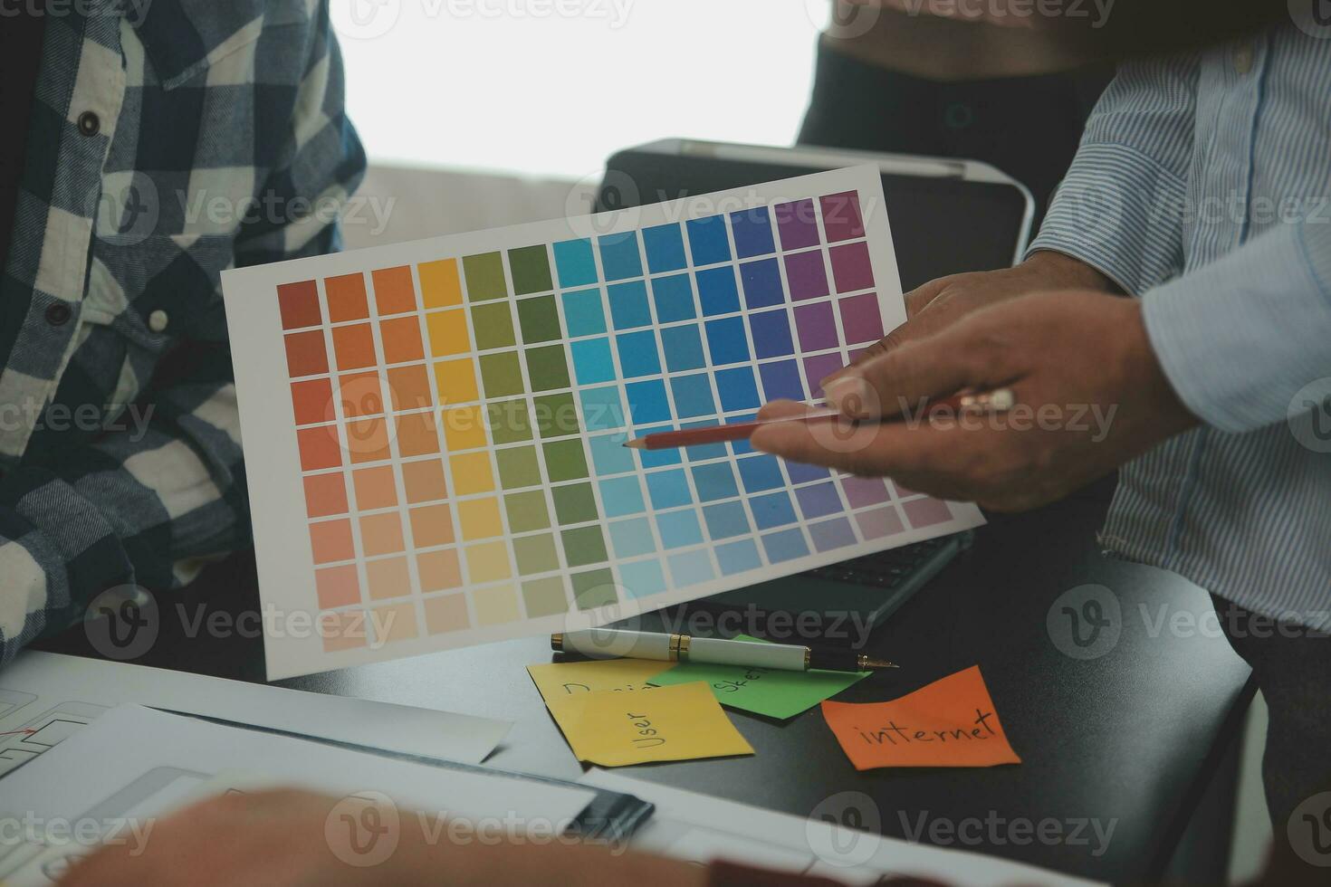 Close up ux developer and ui designer brainstorming about mobile app interface wireframe design on table with customer breif and color code at modern office.Creative digital development agency photo