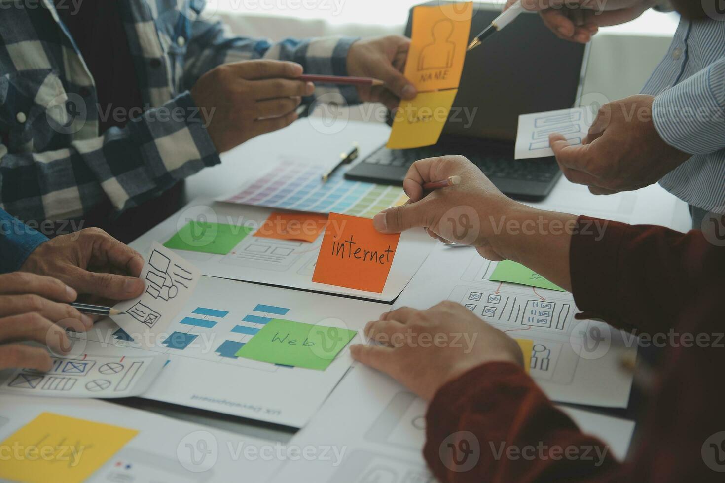 Close up ux developer and ui designer brainstorming about mobile app interface wireframe design on table with customer breif and color code at modern office.Creative digital development agency photo