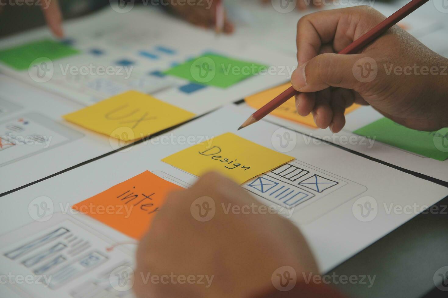 Close up ux developer and ui designer brainstorming about mobile app interface wireframe design on table with customer breif and color code at modern office.Creative digital development agency photo