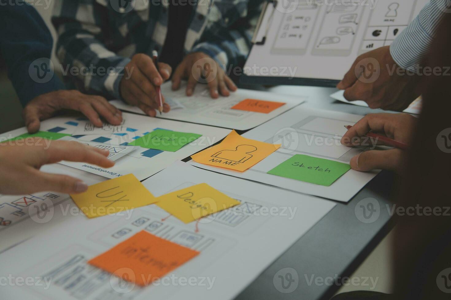 Close up ux developer and ui designer brainstorming about mobile app interface wireframe design on table with customer breif and color code at modern office.Creative digital development agency photo