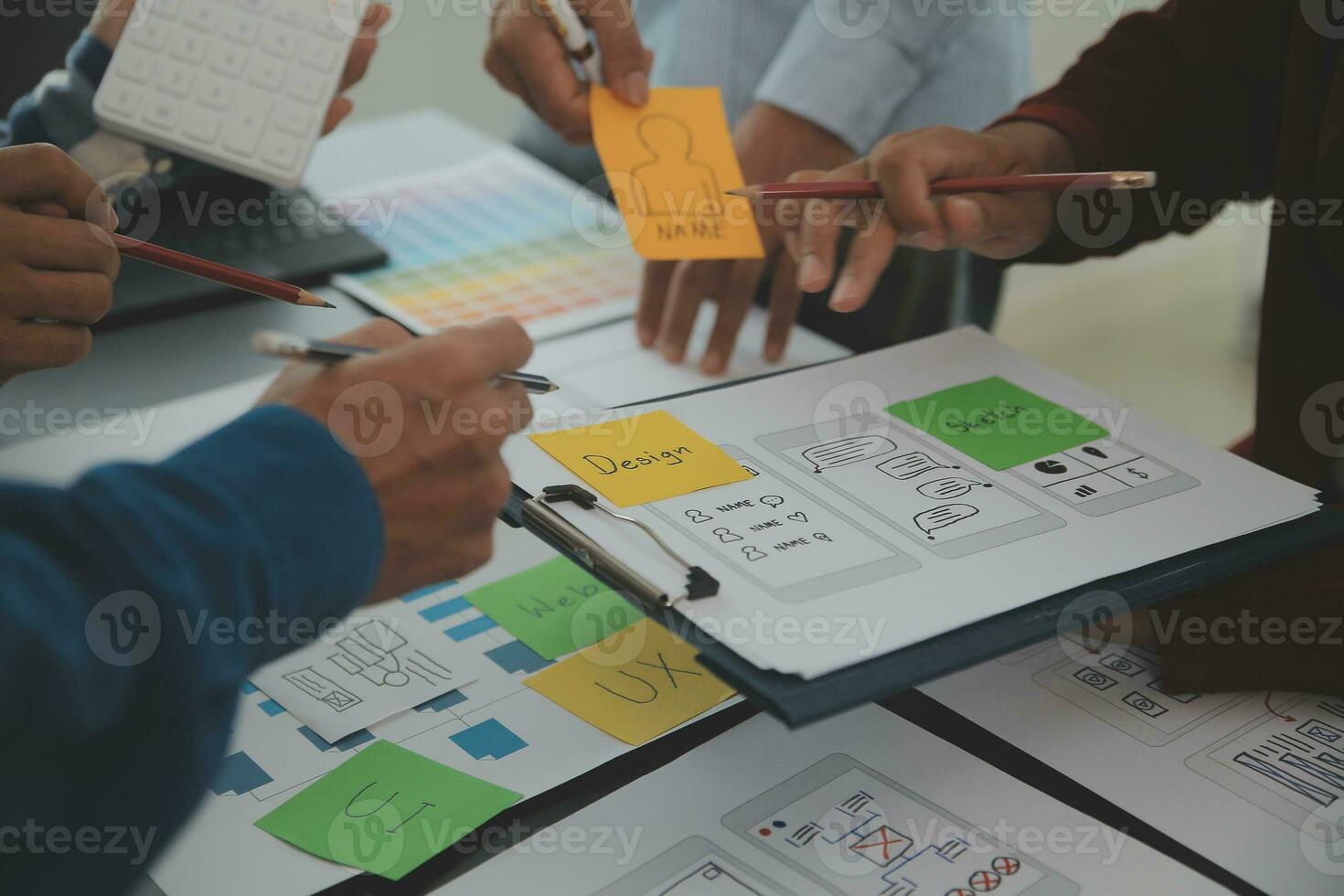 Close up ux developer and ui designer brainstorming about mobile app interface wireframe design on table with customer breif and color code at modern office.Creative digital development agency photo
