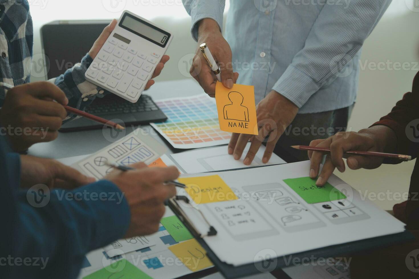 Close up ux developer and ui designer brainstorming about mobile app interface wireframe design on table with customer breif and color code at modern office.Creative digital development agency photo