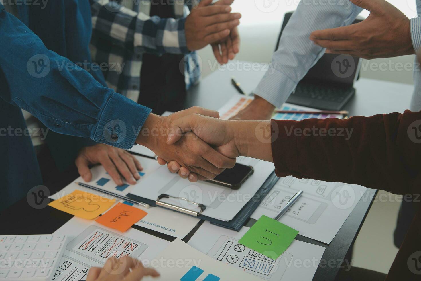 Close up ux developer and ui designer brainstorming about mobile app interface wireframe design on table with customer breif and color code at modern office.Creative digital development agency photo