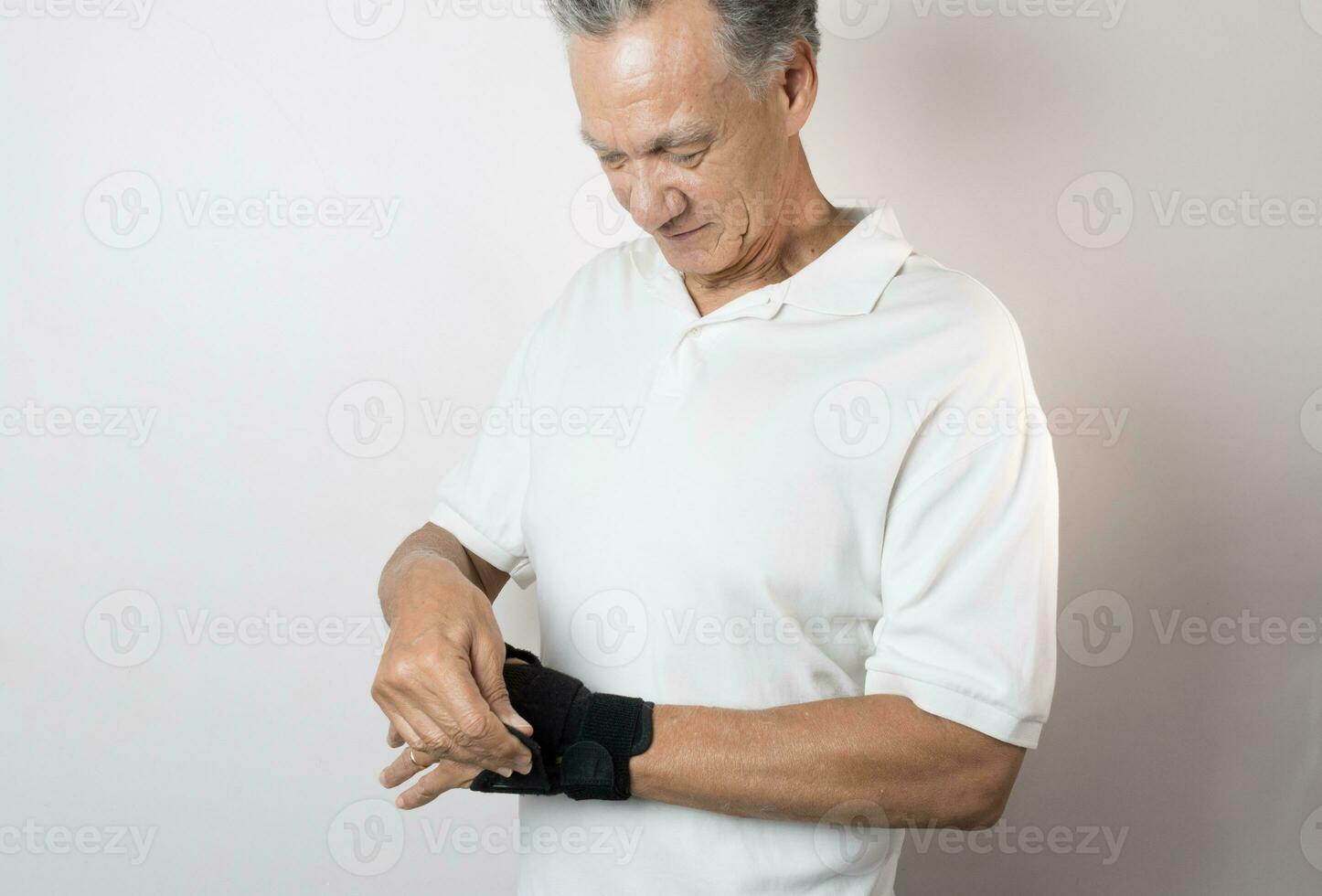 Senior Man wearing a wrist brace on his left hand and wrist for pain management photo
