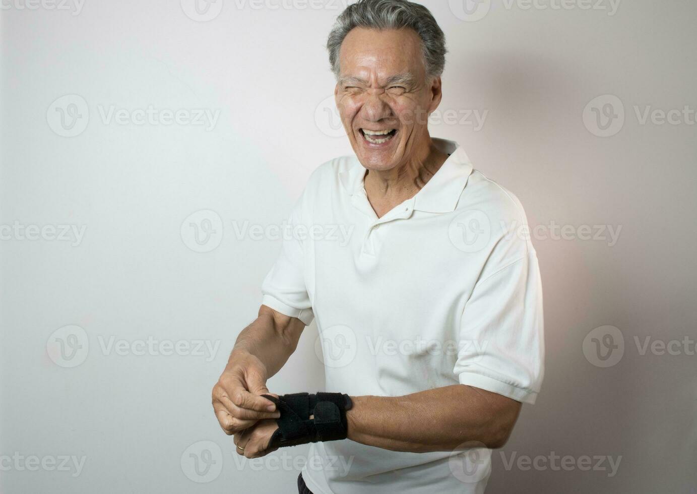 Senior Man wearing a wrist brace on his left hand and wrist for pain management photo