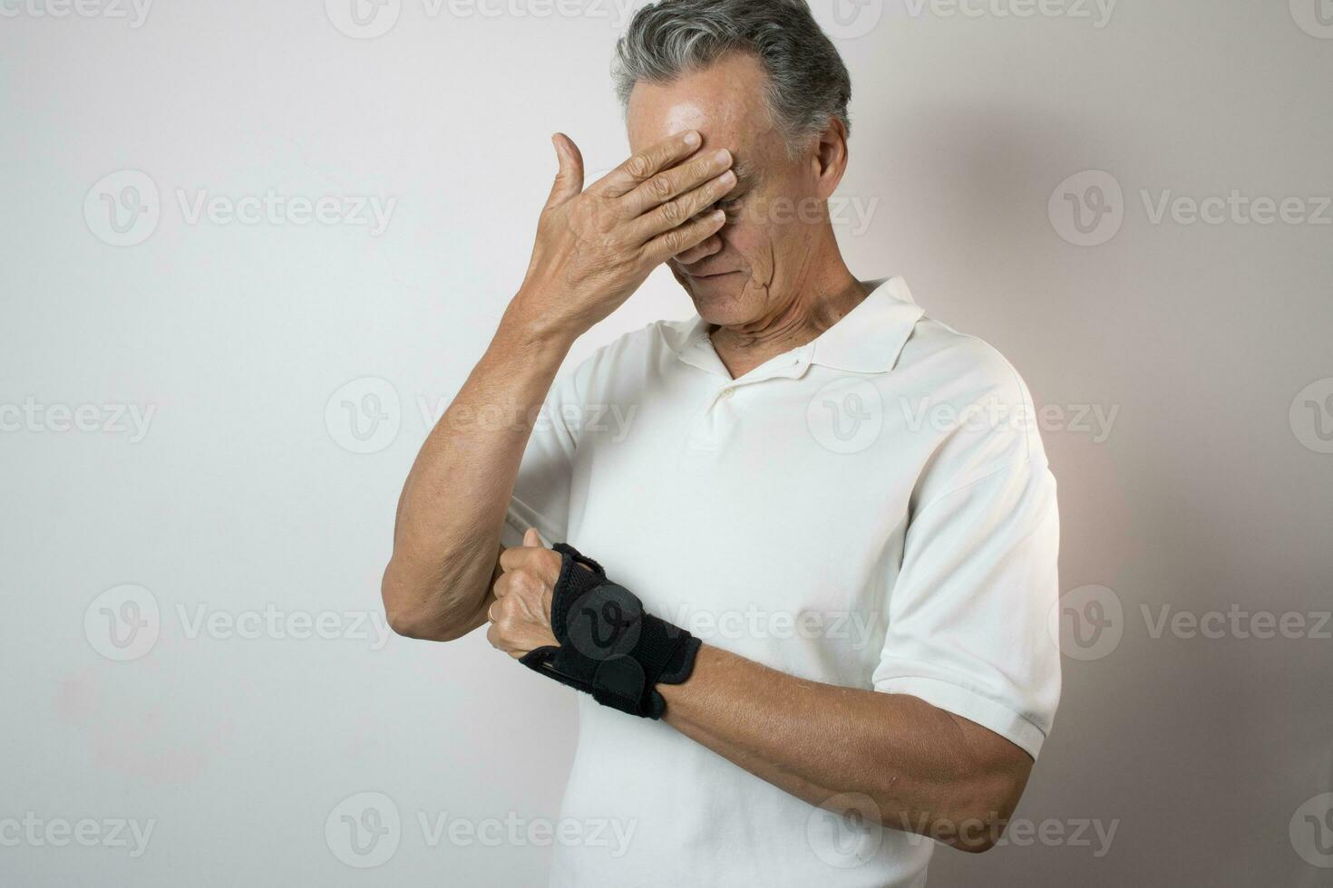 Senior Man wearing a wrist brace on his left hand and wrist for pain management photo