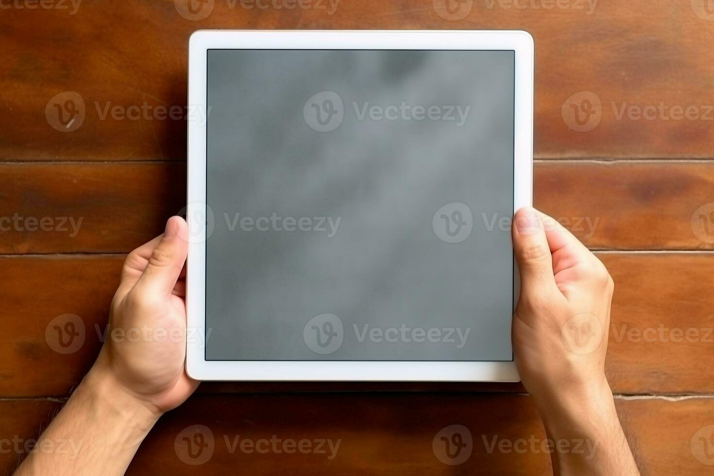 Top view hand holding tablet on wooden table photo