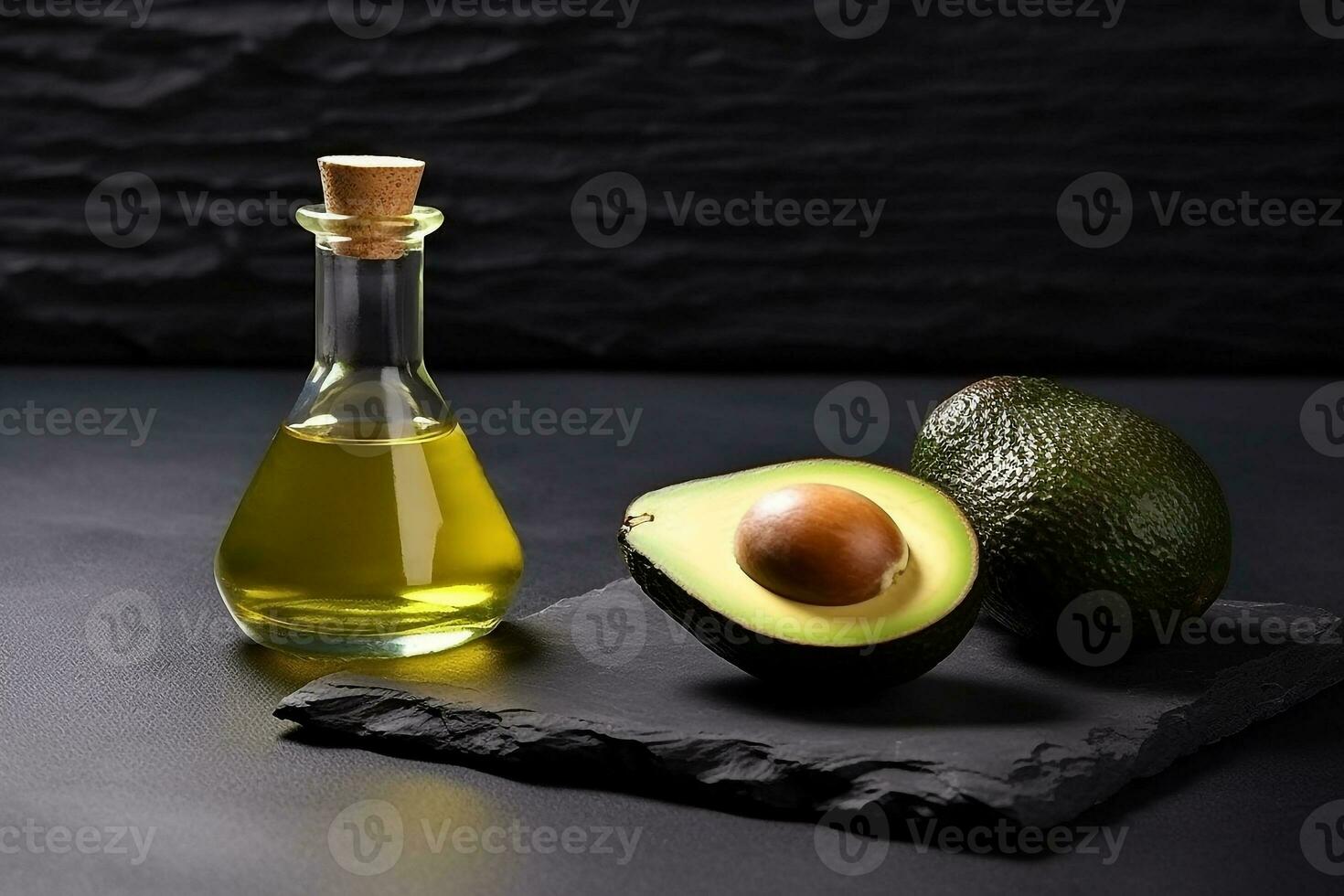 aguacate petróleo con Fresco aguacate en negro Roca antecedentes foto