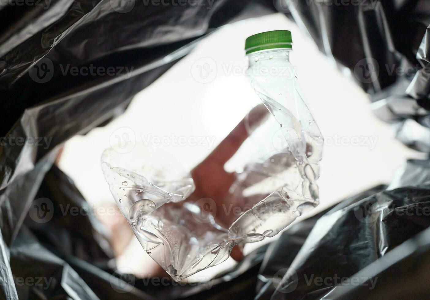 Image from inside yellow recycling bag of man throwing empty plastic bottle in recycling bin Home recycle eco green zero concept. photo