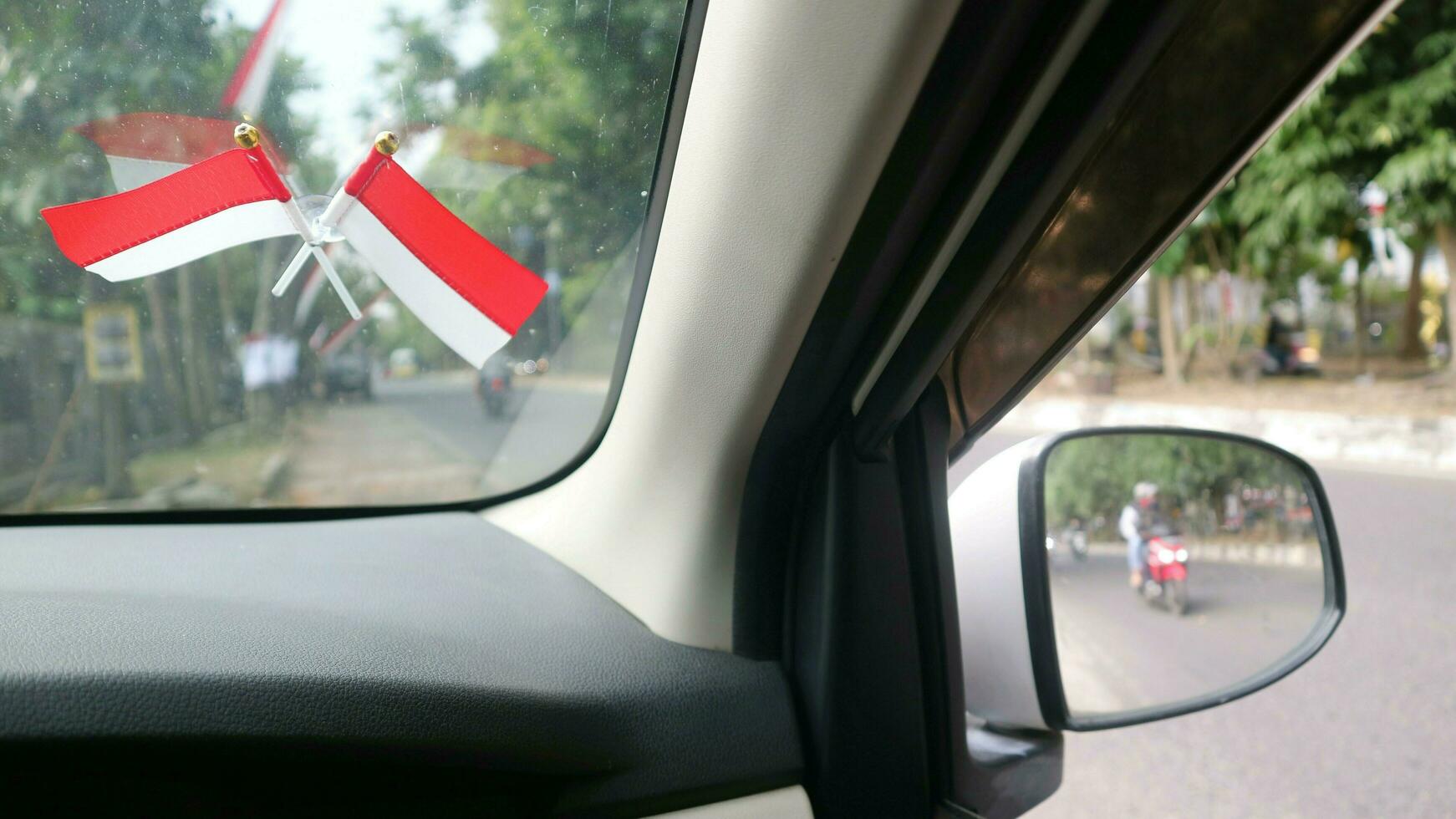 The Indonesian flag is mounted on the windshield of the car to welcome Indonesia's independence day photo