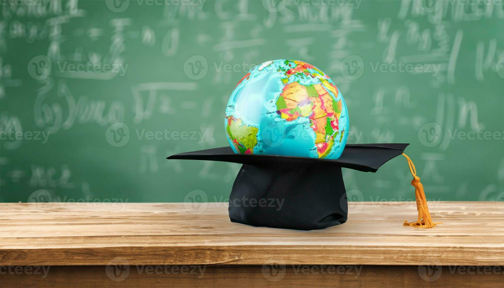 globe, pencil, pen and book on a green blackboard background and empty space on left side photo