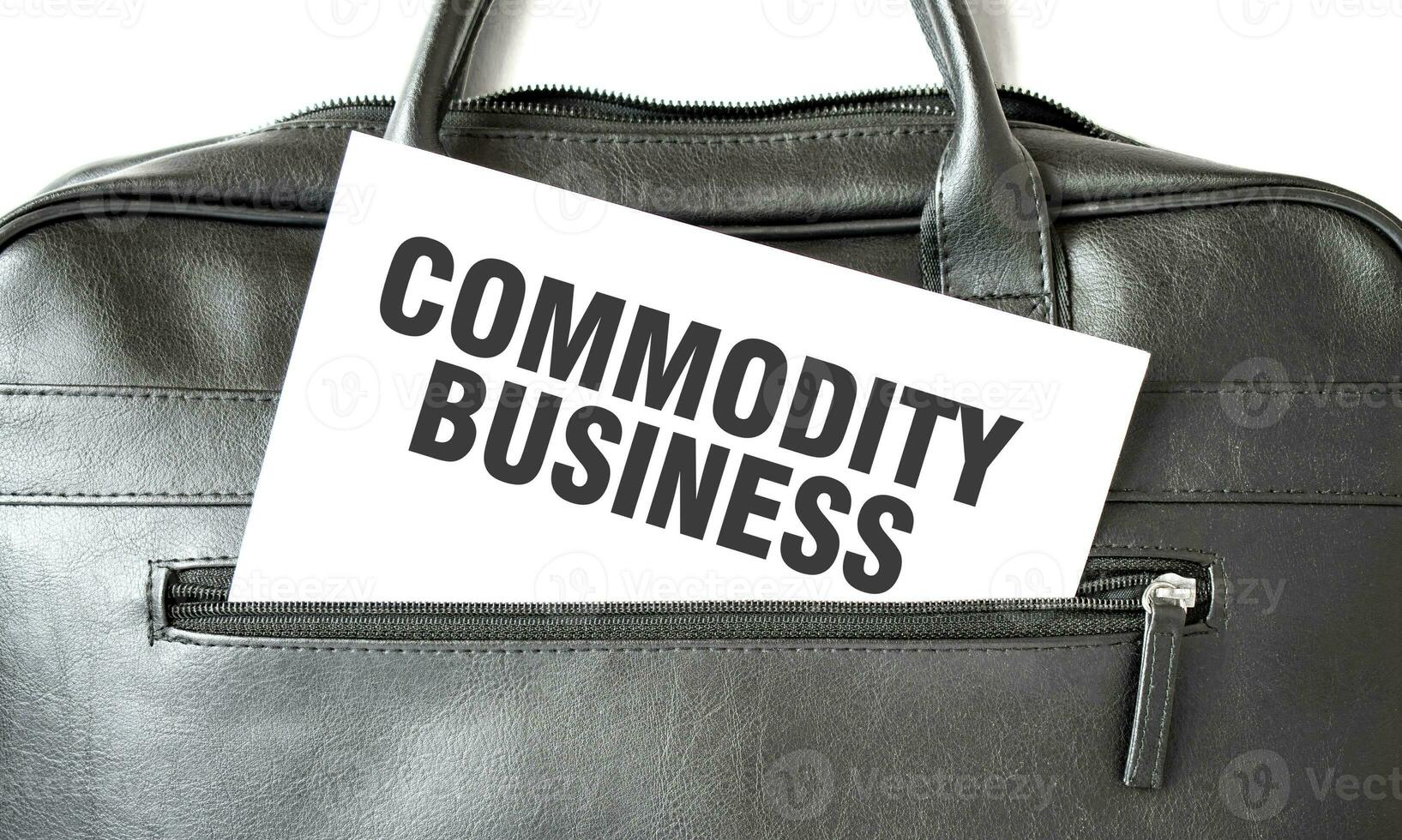 Text COMMODITY BUSINESS writing on white paper sheet in the black business bag. Business concept photo