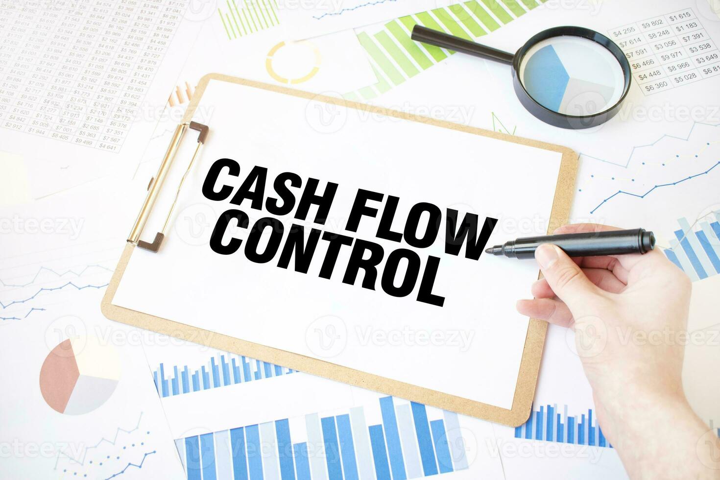 Text CASH FLOW CONTROL on white paper sheet and marker on businessman hand on the diagram. Business concept photo