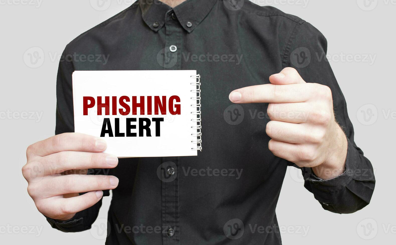 Businessman holding a white notepad with text PHISHING ALERT, business concept photo