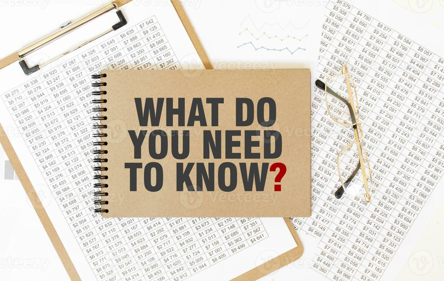 Craft colour notepad with text WHAT DO YOU NEED TO KNOW. Notepad with eyeglasses and text documents. Business concept photo