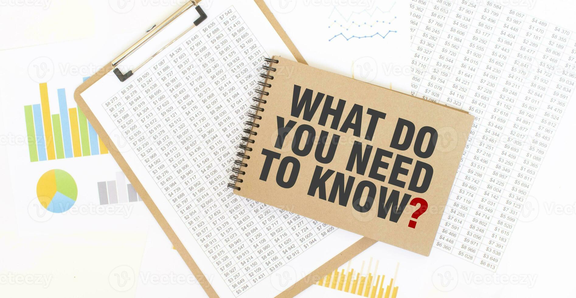 Text WHAT DO YOU NEED TO KNOW on brown paper notepad on the table with diagram. Business concept photo
