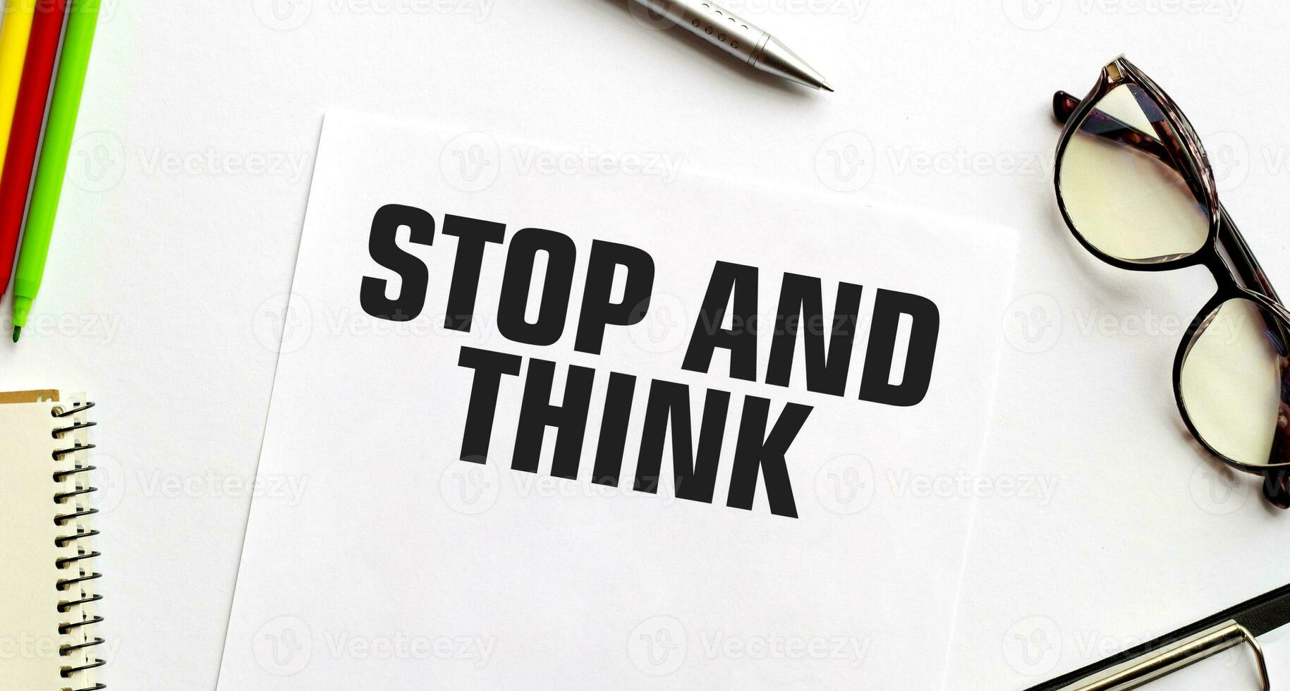 STOP AND THINK on paper with glasses and pen photo