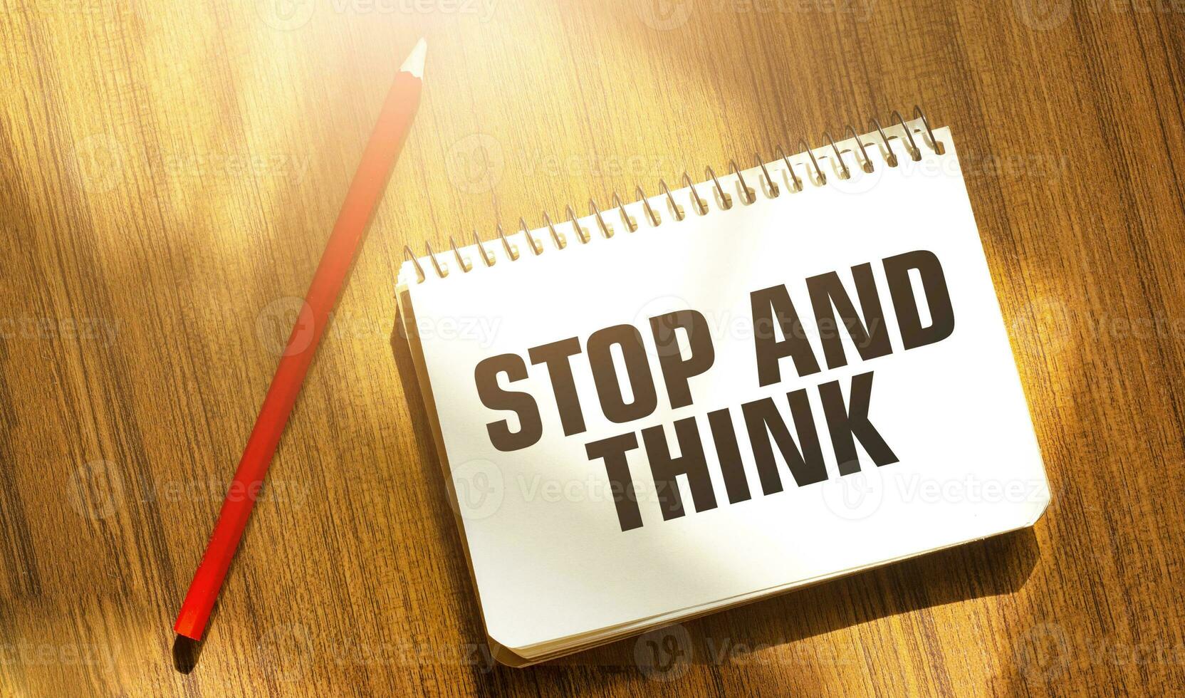 STOP AND THINK words on notebook with red pencil photo