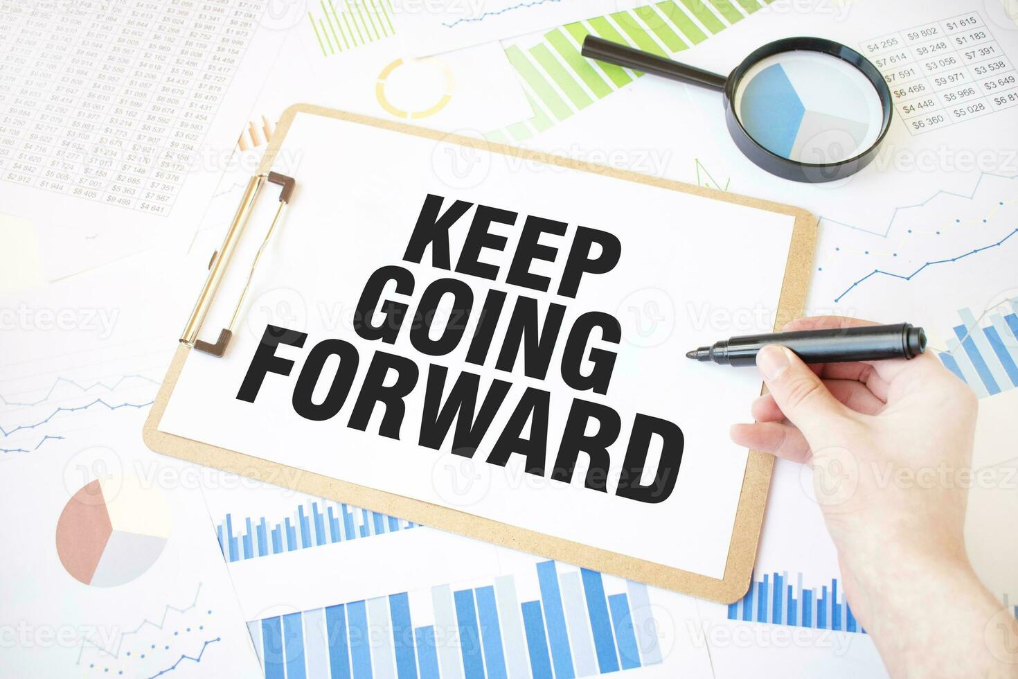 Text KEEP GOING FORWARD on white paper sheet and marker on businessman hand on the diagram. Business concept photo