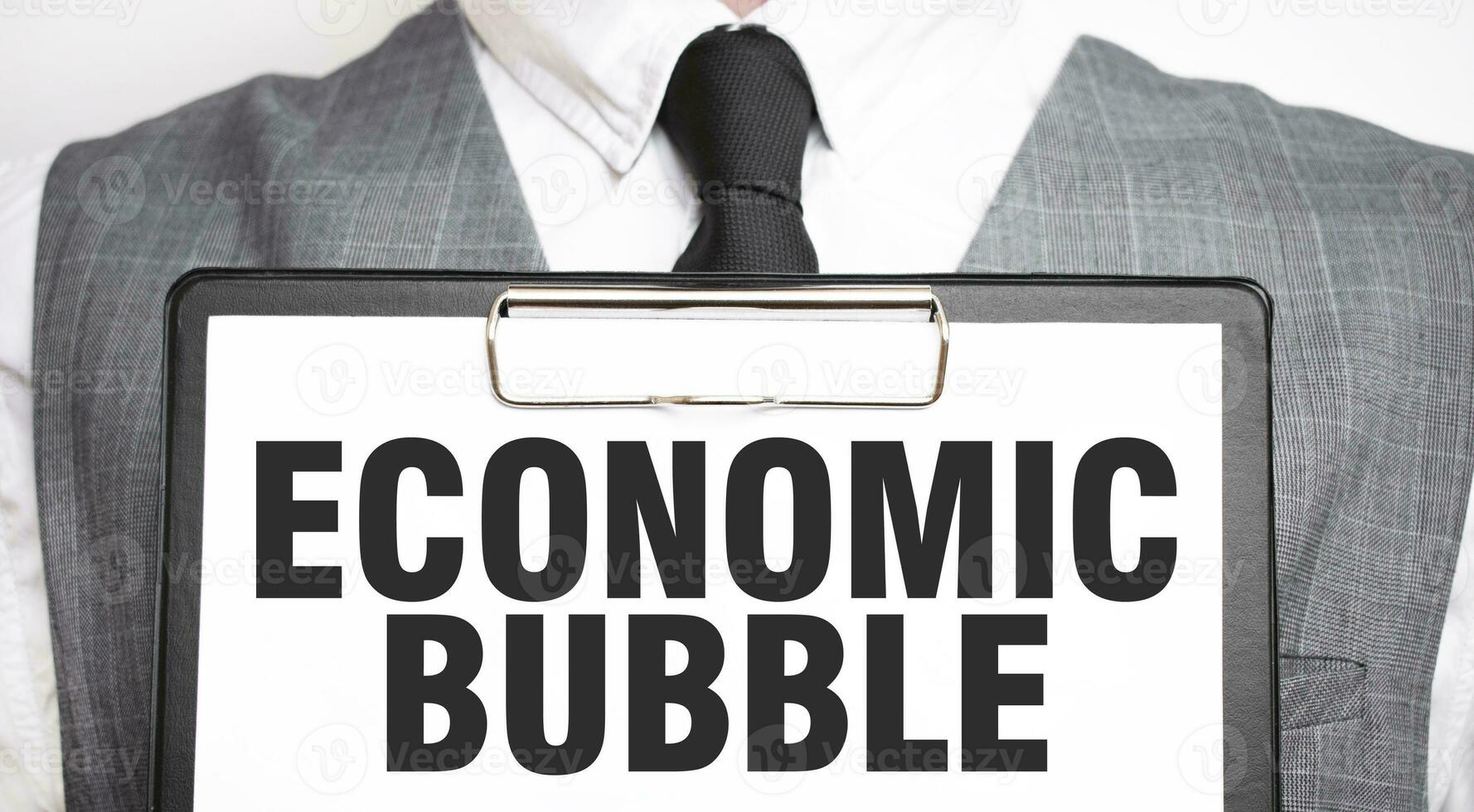 Businessman holding sheet of paper with a message ECONOMIC BUBBLE photo