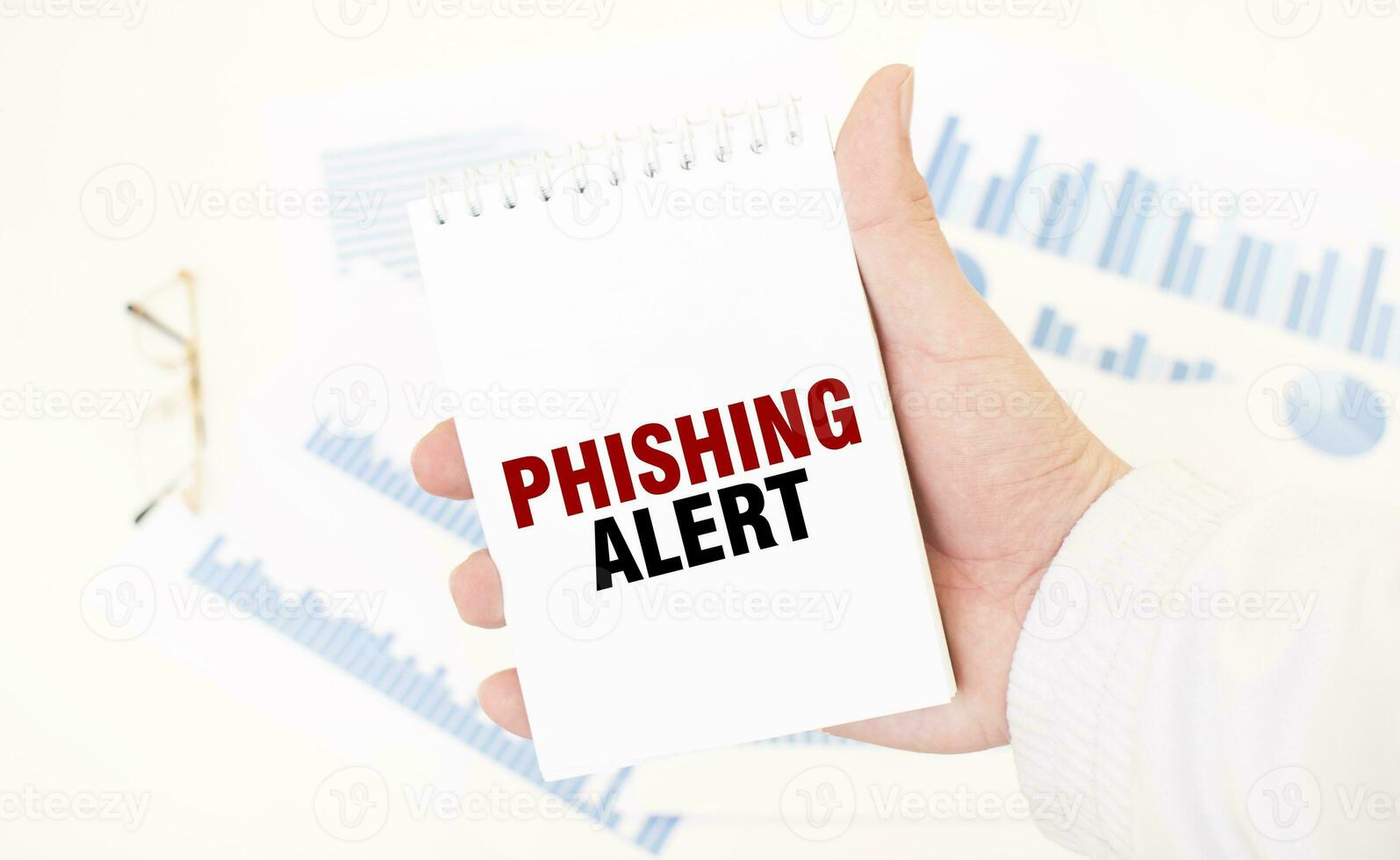 Businessman holding a white notepad with text PHISHING ALERT, business concept photo
