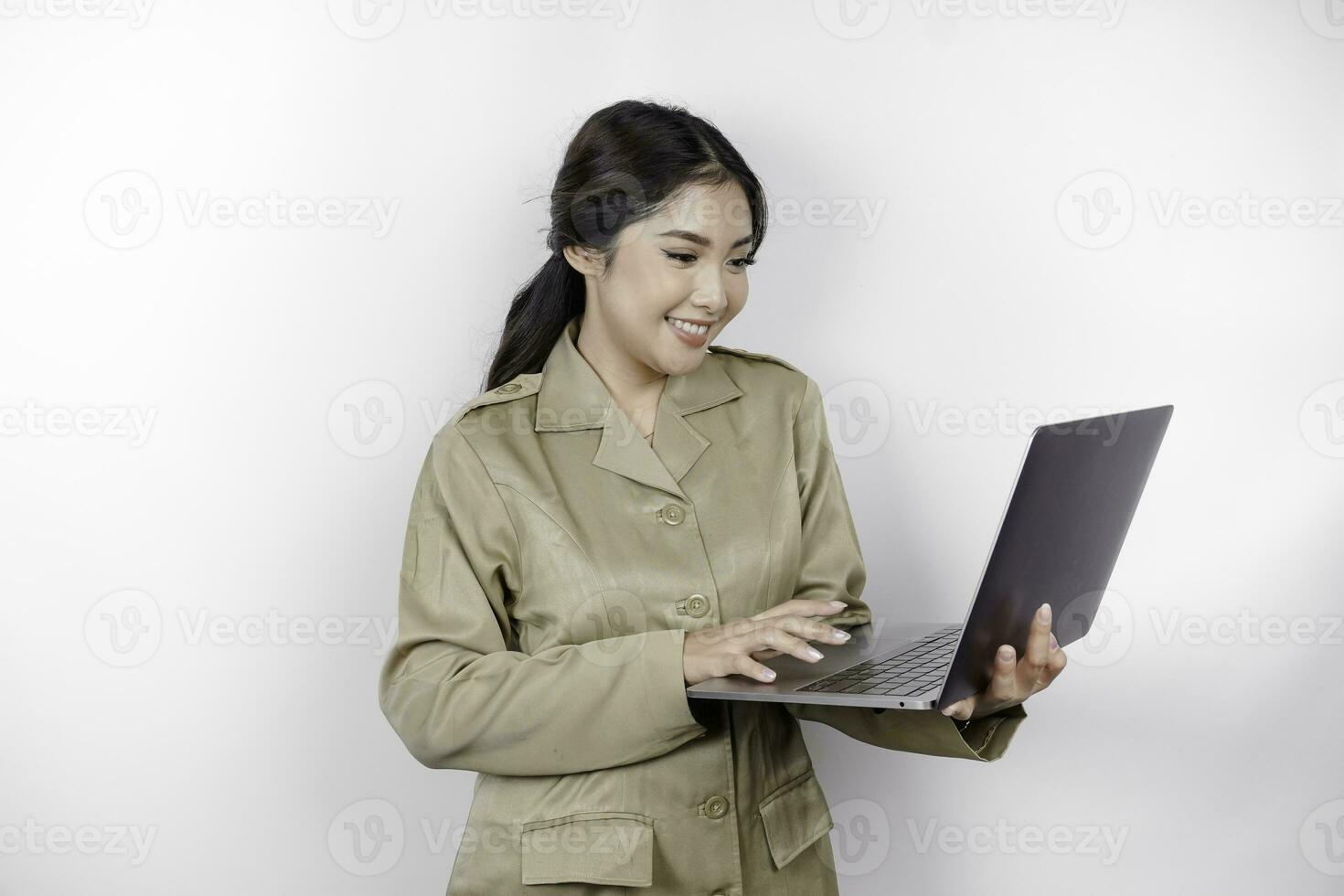 contento gobierno trabajador mujer participación su ordenador portátil mientras sonriente. pns vistiendo caqui uniforme. foto