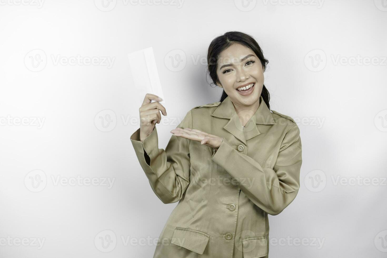 A happy young beautiful Asian worker wearing brown uniform holding an envelope. Indonesian PNS concept. photo