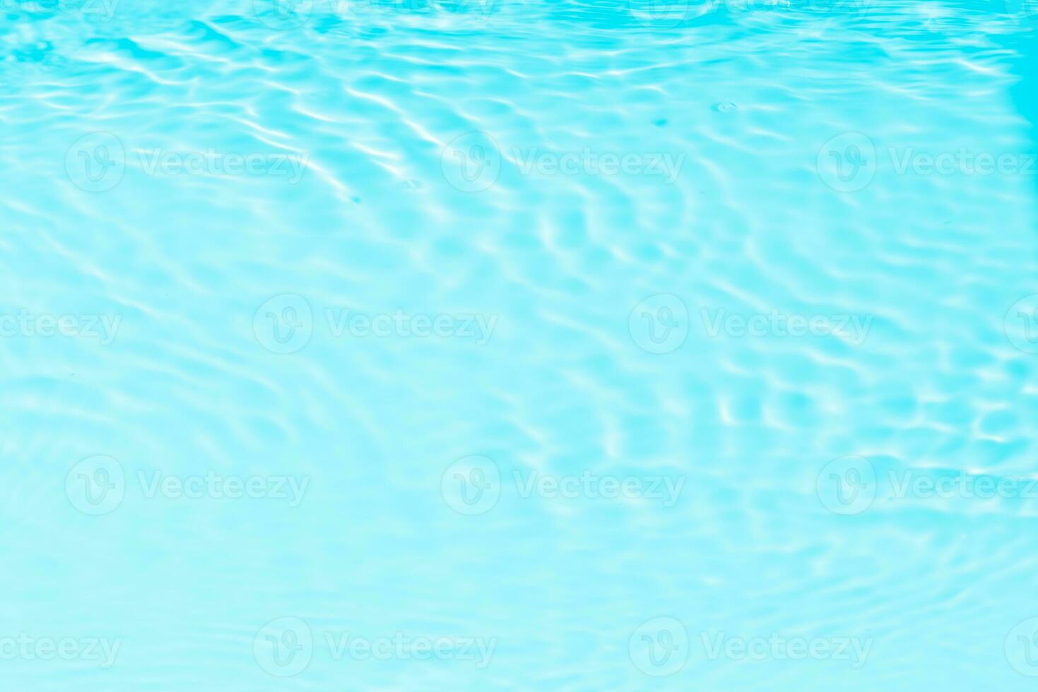 Blue water with ripples on the surface. Defocus blurred transparent blue colored clear calm water surface texture with splashes and bubbles. Water waves with shining pattern texture background. photo