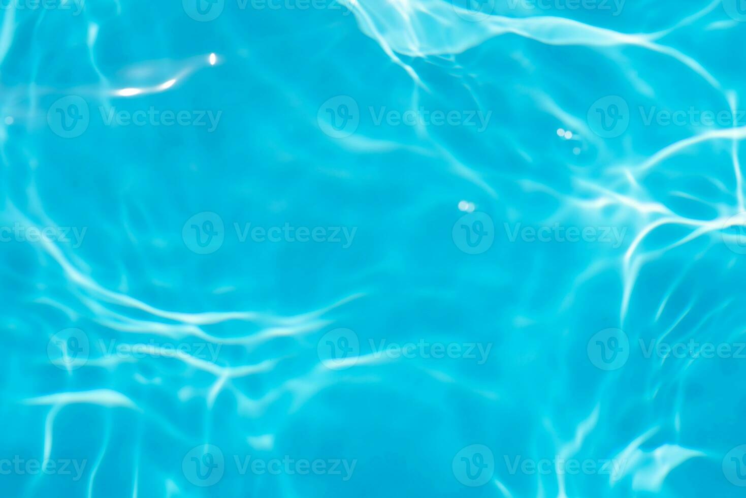 Blue water with ripples on the surface. Defocus blurred transparent blue colored clear calm water surface texture with splashes and bubbles. Water waves with shining pattern texture background. photo