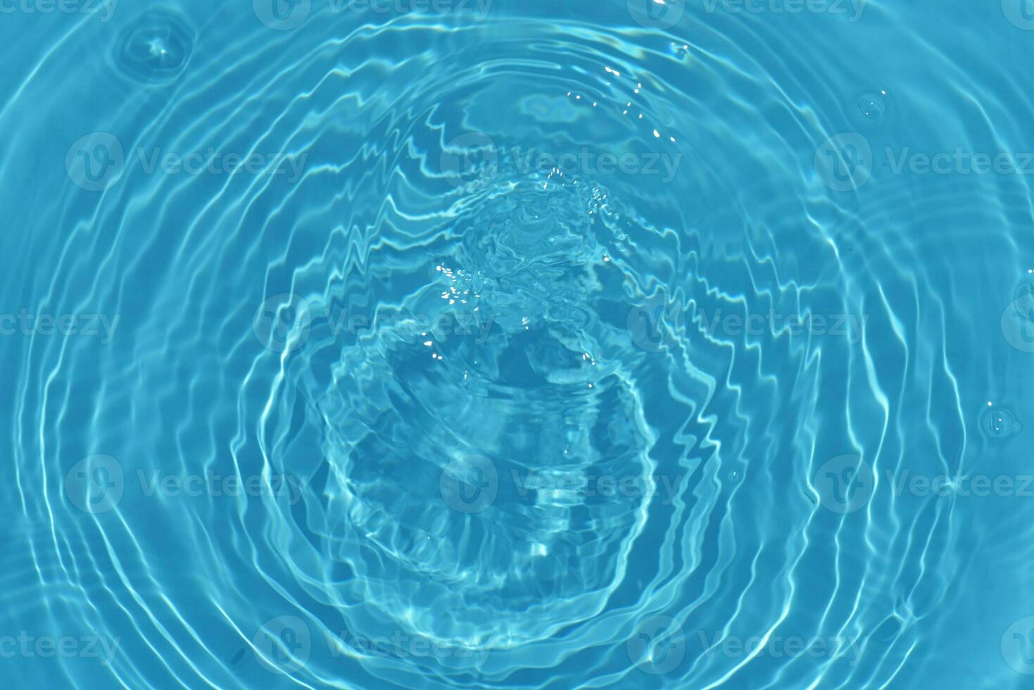 Blue water with ripples on the surface. Defocus blurred transparent blue colored clear calm water surface texture with splashes and bubbles. Water waves with shining pattern texture background. photo