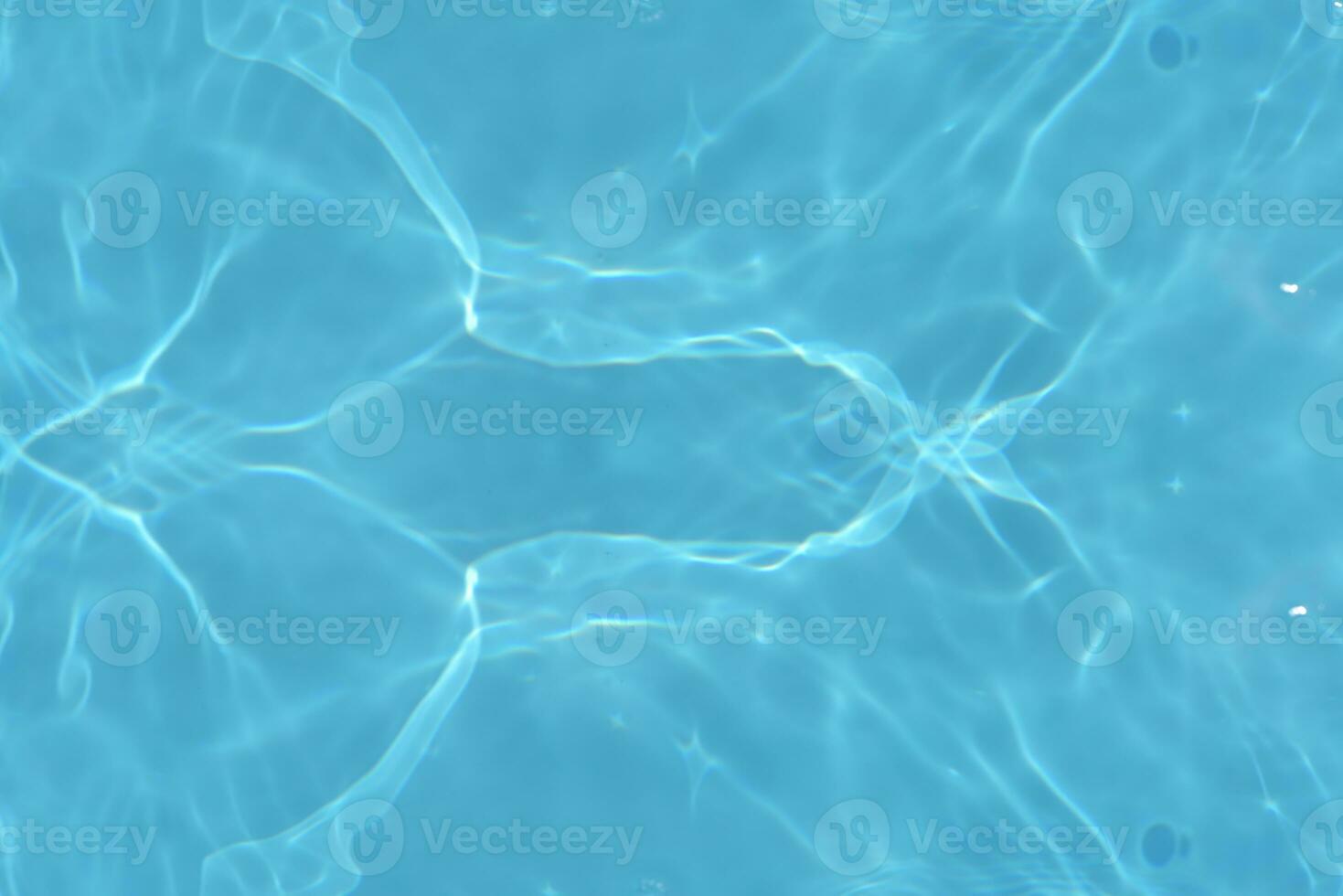Blue water with ripples on the surface. Defocus blurred transparent blue colored clear calm water surface texture with splashes and bubbles. Water waves with shining pattern texture background. photo