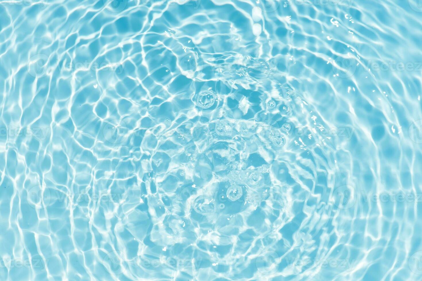 Blue water with ripples on the surface. Defocus blurred transparent blue colored clear calm water surface texture with splashes and bubbles. Water waves with shining pattern texture background. photo