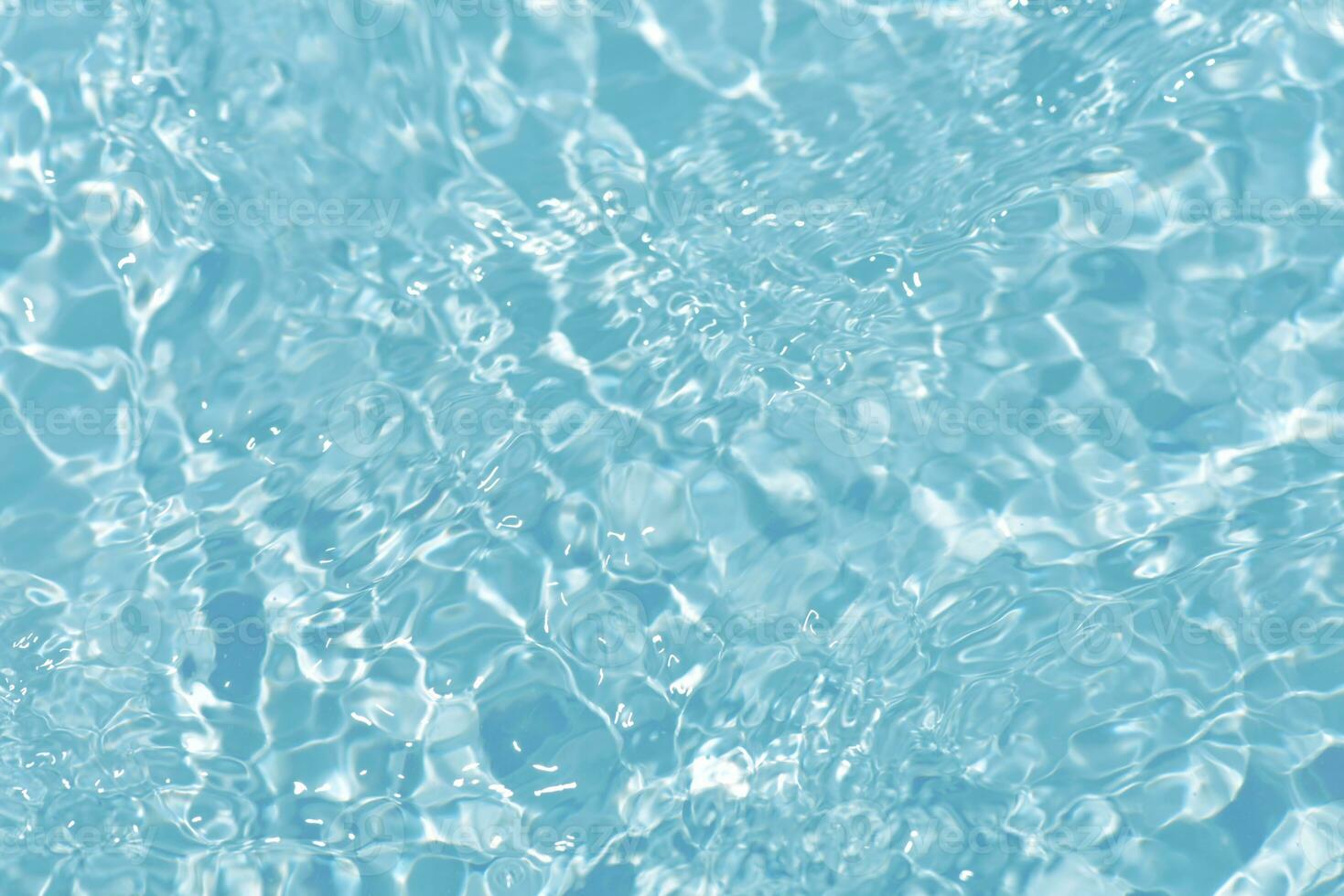 Blue water with ripples on the surface. Defocus blurred transparent blue colored clear calm water surface texture with splashes and bubbles. Water waves with shining pattern texture background. photo