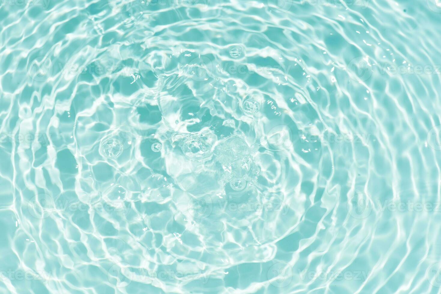 Blue water with ripples on the surface. Defocus blurred transparent blue colored clear calm water surface texture with splashes and bubbles. Water waves with shining pattern texture background. photo
