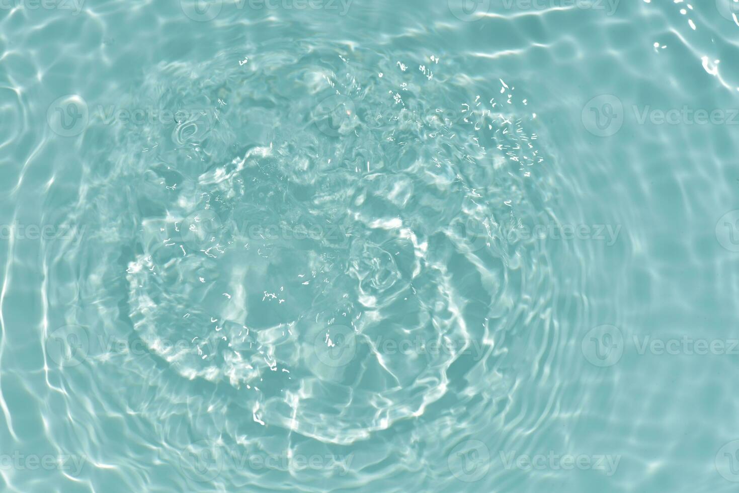 Blue water with ripples on the surface. Defocus blurred transparent blue colored clear calm water surface texture with splashes and bubbles. Water waves with shining pattern texture background. photo