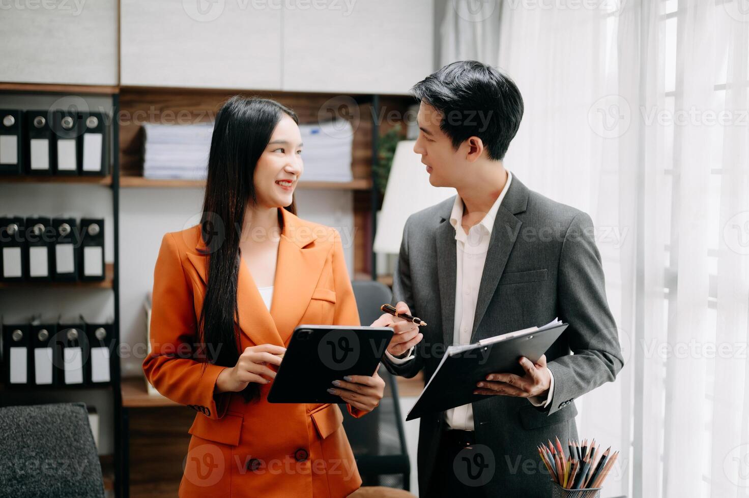 Two Asian businesswoman discuss investment project working and planning strategy with tablet laptop computer in  office. photo