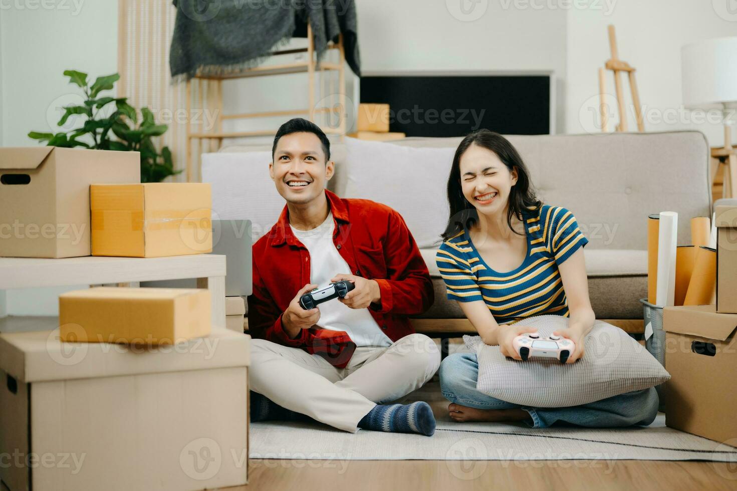 Asian young attractive couple man and woman use tablet and smartphone online shopping furniture decorate house with carton package move in new house. photo