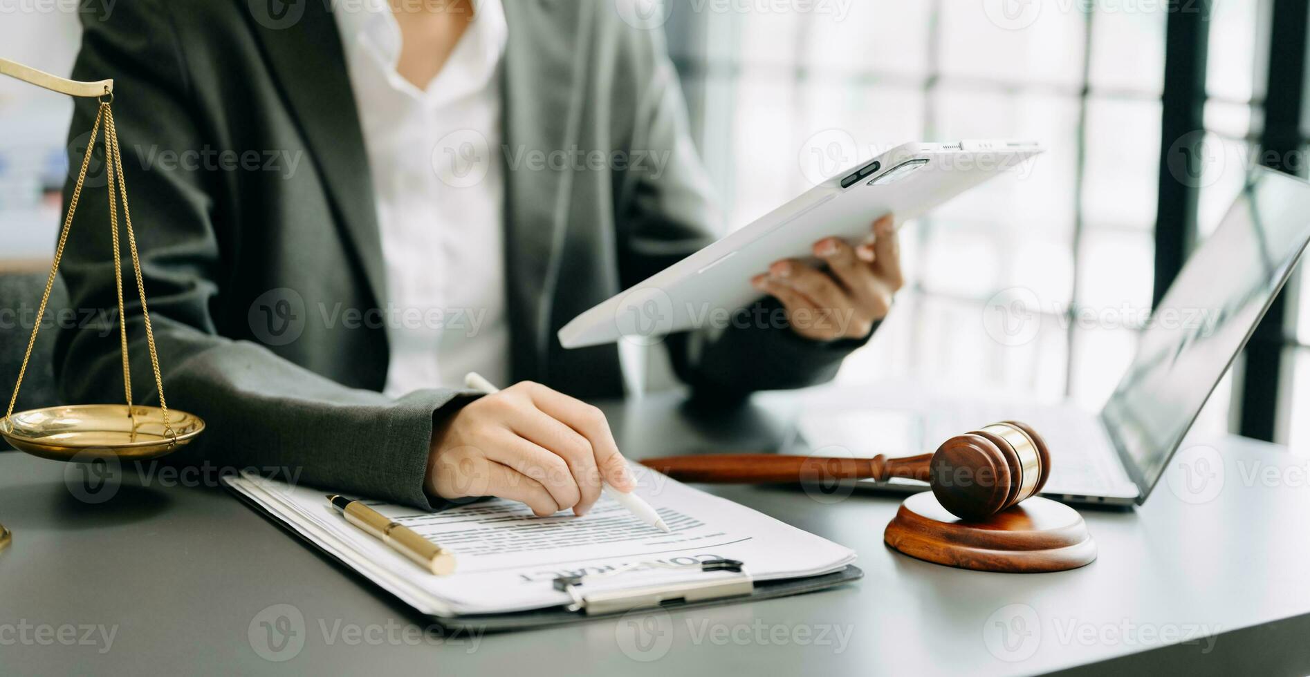 justice and law concept. Male judge in a courtroom the gavel, working with smart phone and laptop and digital tablet computer on table photo