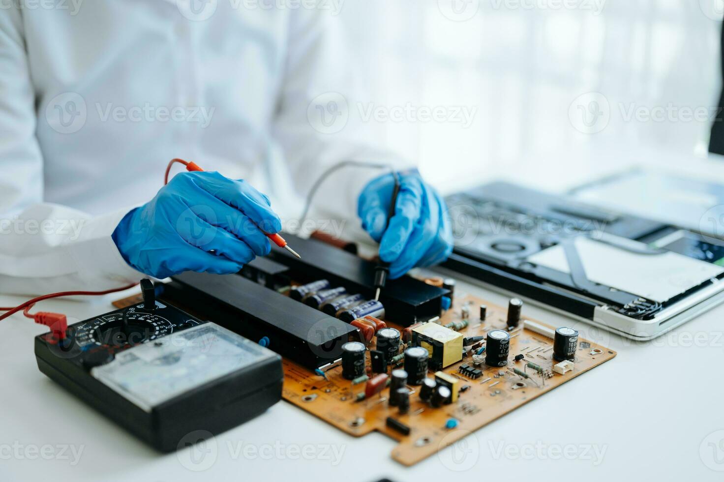 Electronics technician, electronic engineering electronic repair,electronics measuring and testing, repair and maintenance concepts.uses a voltage meter to check and upgrade photo
