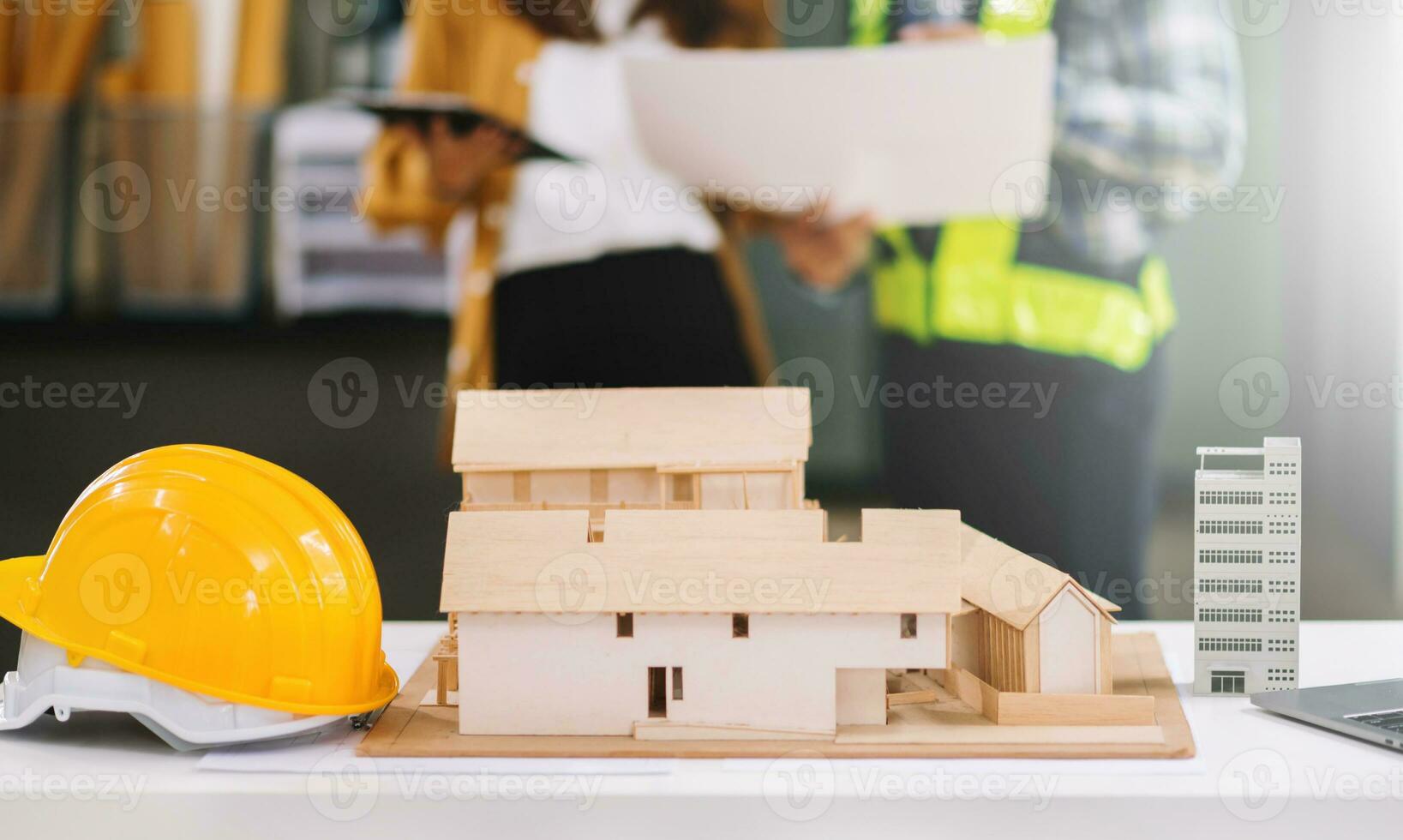 Engineer desk with object paper and tablet with blurry engineer teamwork hardworking to consults about their building project. photo