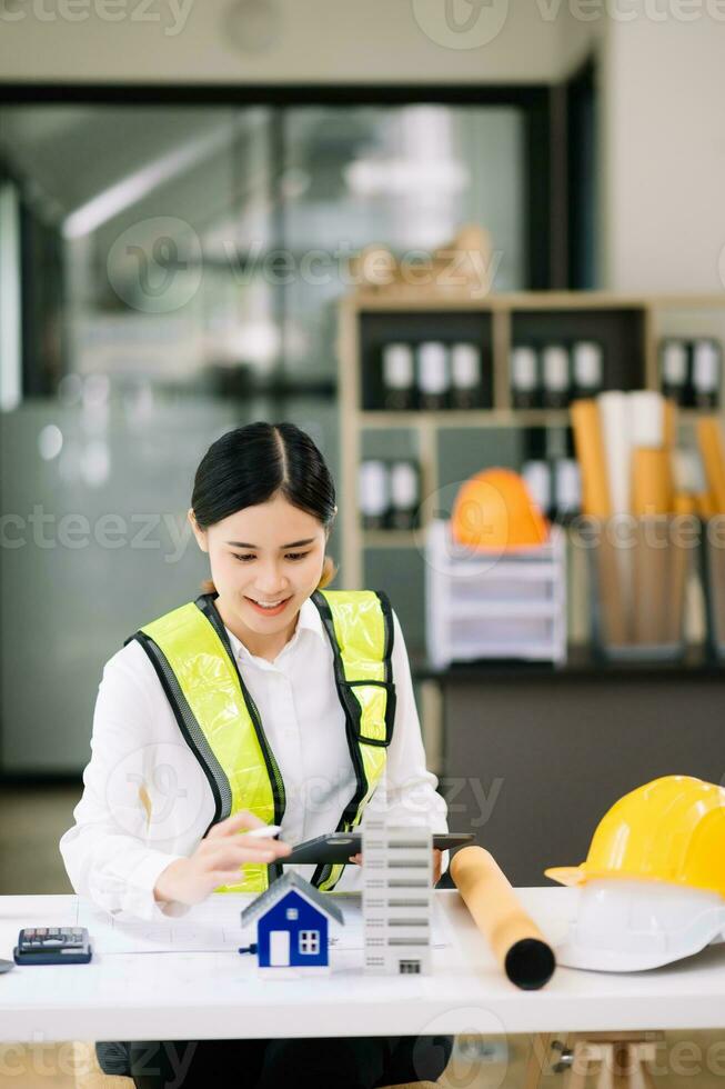 Creative architect projecting on the big drawings working and laptop with on on architectural project at construction site at desk in modern office photo