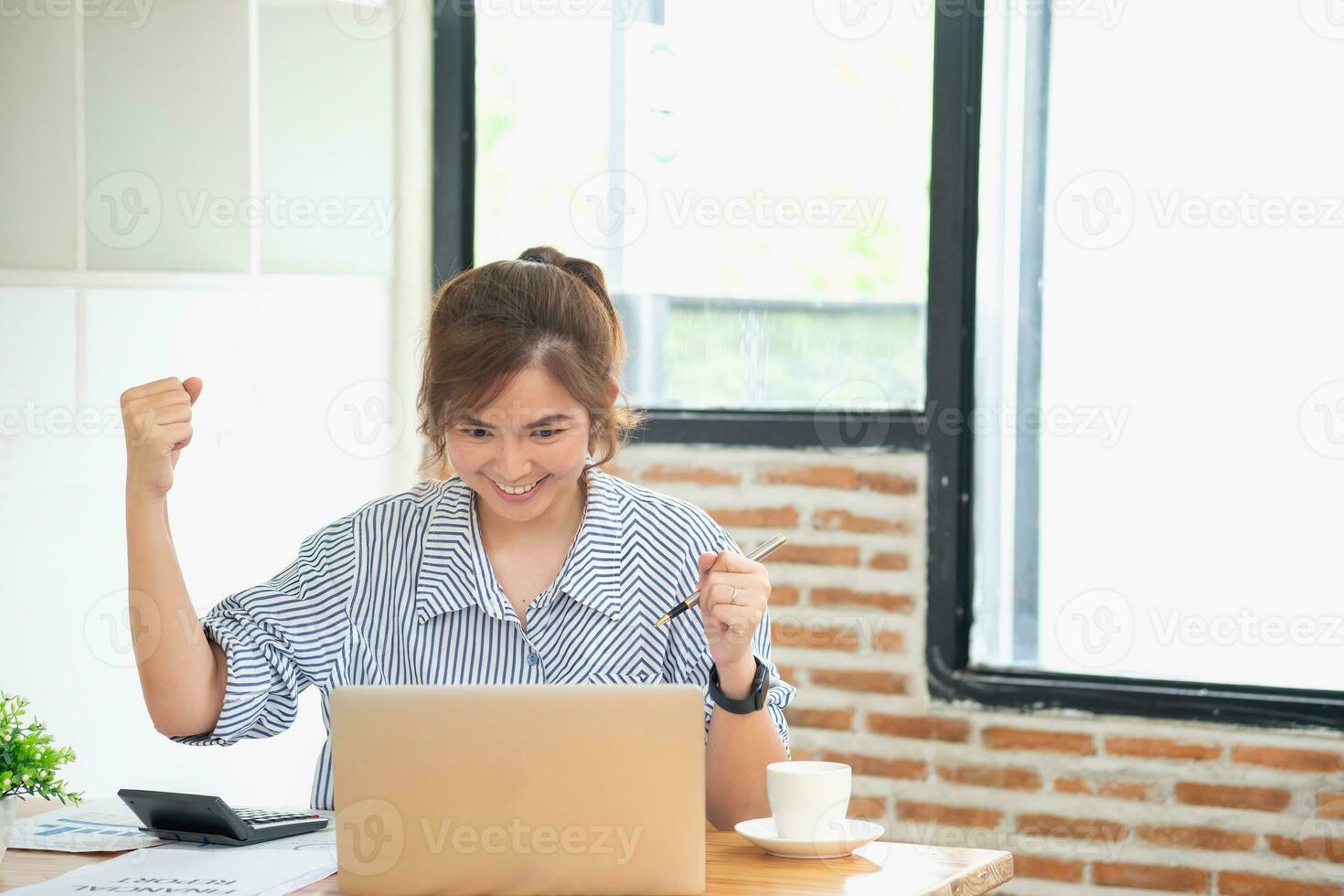 hermosa joven adolescente asiático negocio mujer utilizando computadora ordenador portátil con manos arriba en ganador es un gesto, contento a ser exitosamente celebrando logro éxito. foto