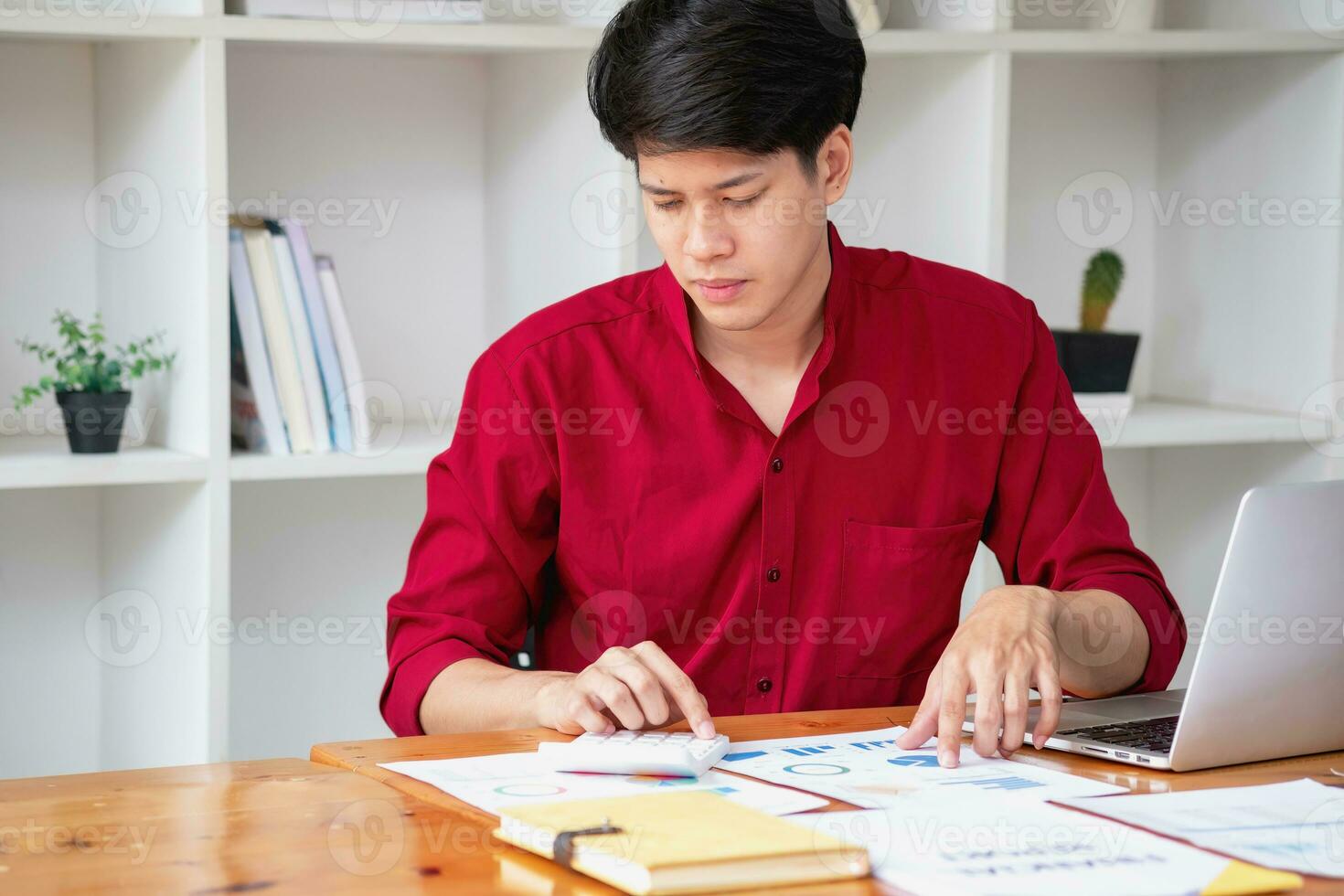 Business accounting concept, A businessman using a calculator with a computer laptop, budget, and loan paper in the office. photo