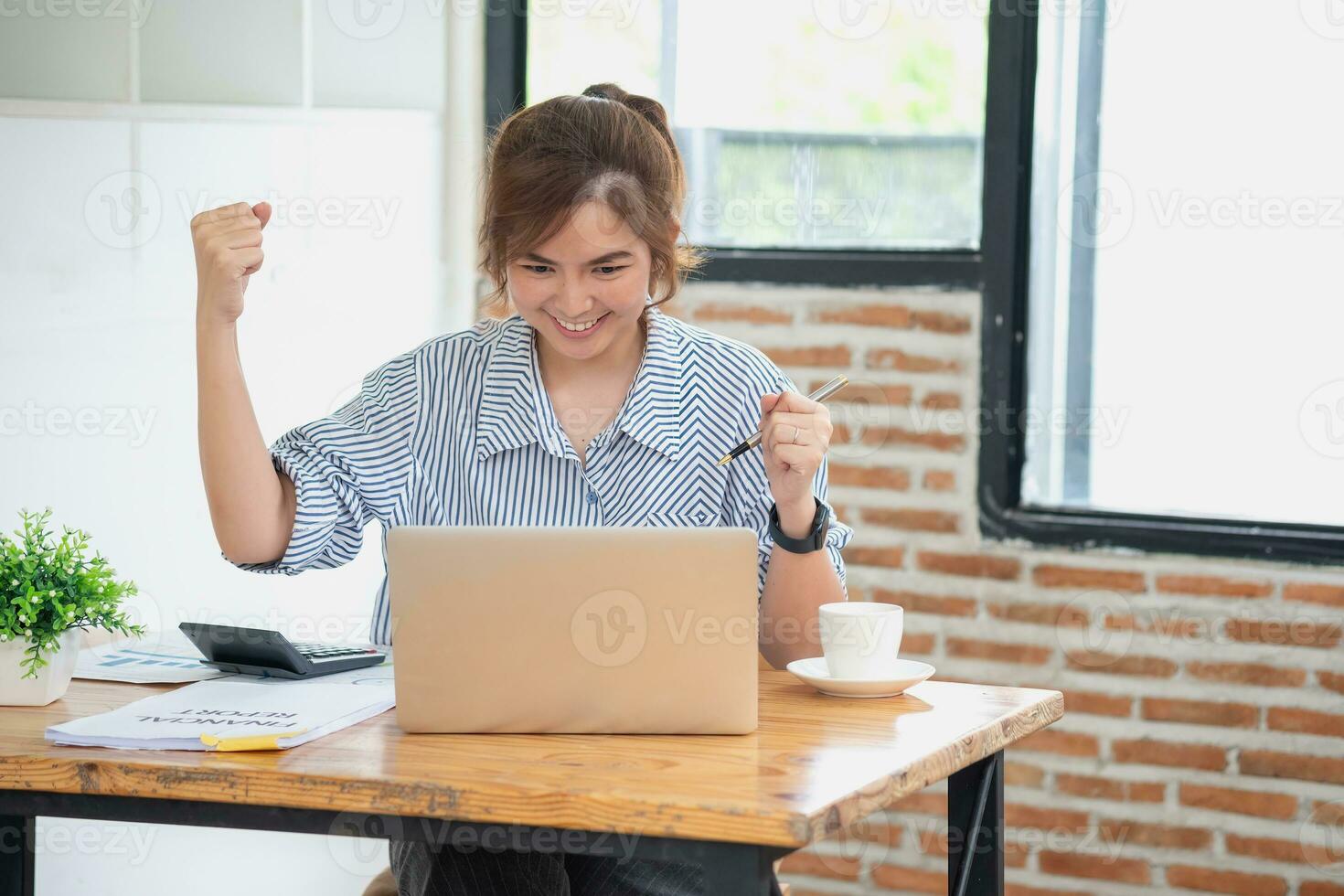 hermosa joven adolescente asiático negocio mujer utilizando computadora ordenador portátil con manos arriba en ganador es un gesto, contento a ser exitosamente celebrando logro éxito. foto