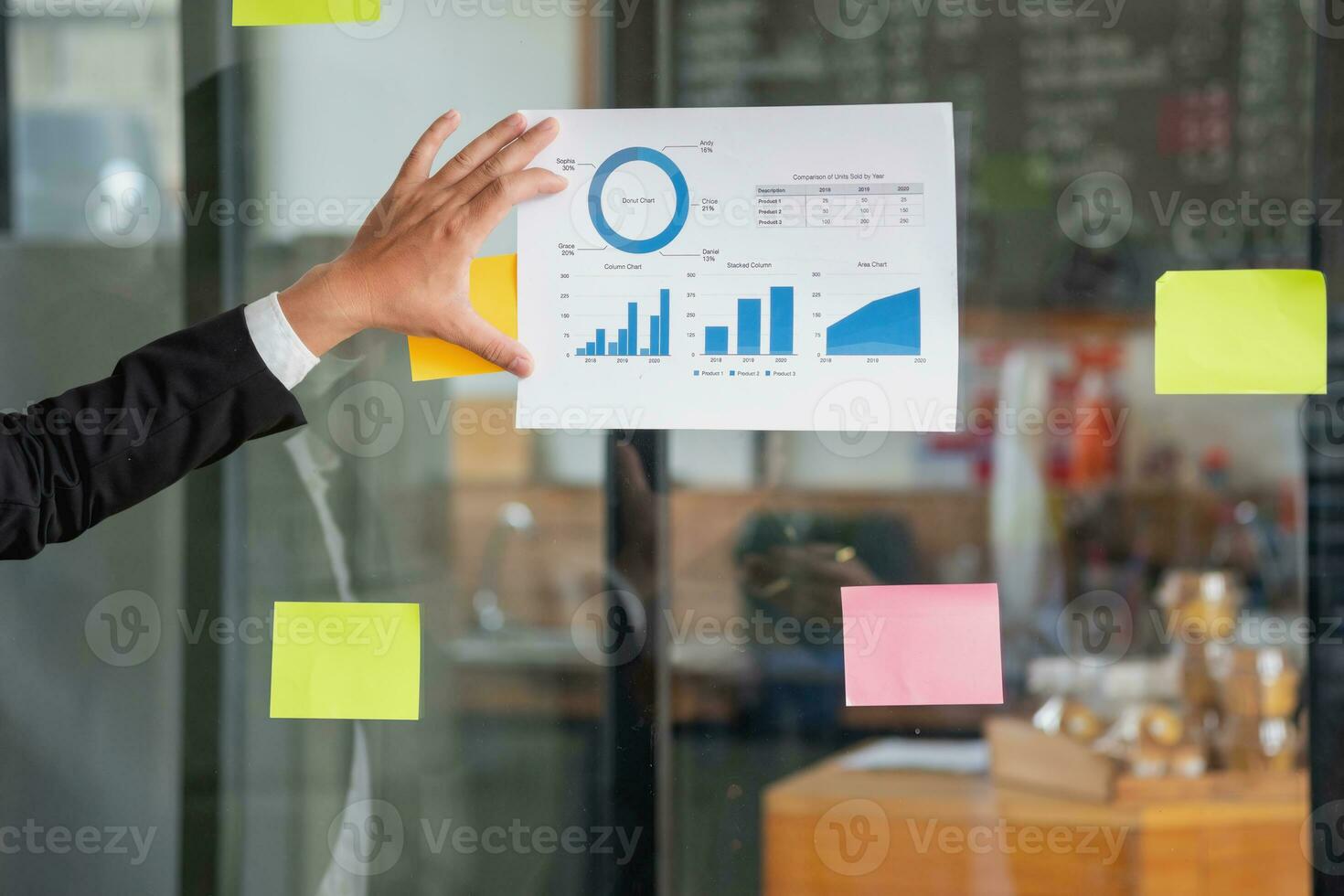 A man employee writes on a colorful notepad. Ethnic women working at startups brainstorm collaborative plans on glass wall stickers See less. photo